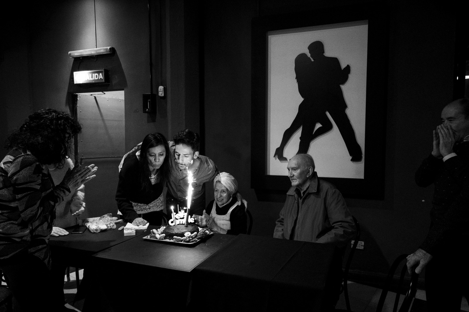 La Sra. Garay y el Sr. Firmani soplando las velas de un pastel de cumpleaños para celebrar sus respectivos cumpleaños, con una semana de diferencia.