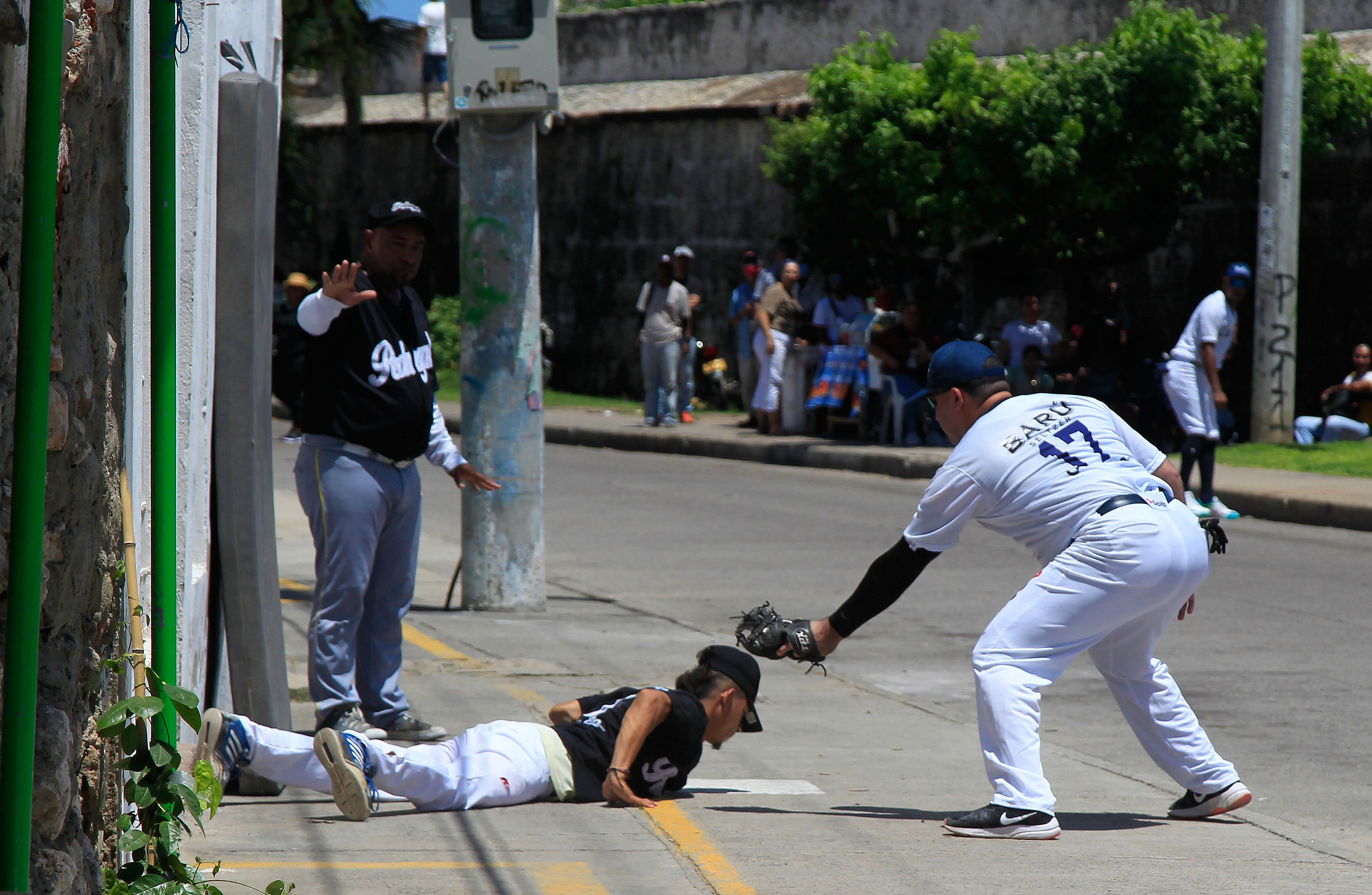 AME1762. CARTAGENA (COLOMBIA), 02/10/2022.- Habitantes del histórico barrio de Getsemaní juegan la final del campeonato de Bola de Trapo, un tradicional juego similar al beisbol que se juega con una bola elaborada con trapos e hilo forrados con un cuero semejando la original pelota caliente, en Cartagena (Colombia). Esta es una tradición que los getsemanicenses tratan de mantener viva a pesar de no contar con ninguna clase de apoyo por parte de las autoridades municipales de la ciudad, y es también una forma de resistencia frente a la fuerte gentrificación que sufre este sector de la ciudad invadido por el turismo. EFE/ Ricardo Maldonado Rozo