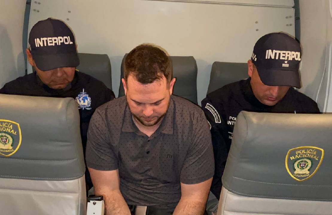 John Poulos viaja en un avión privado custodiado por las autoridades colombianas.