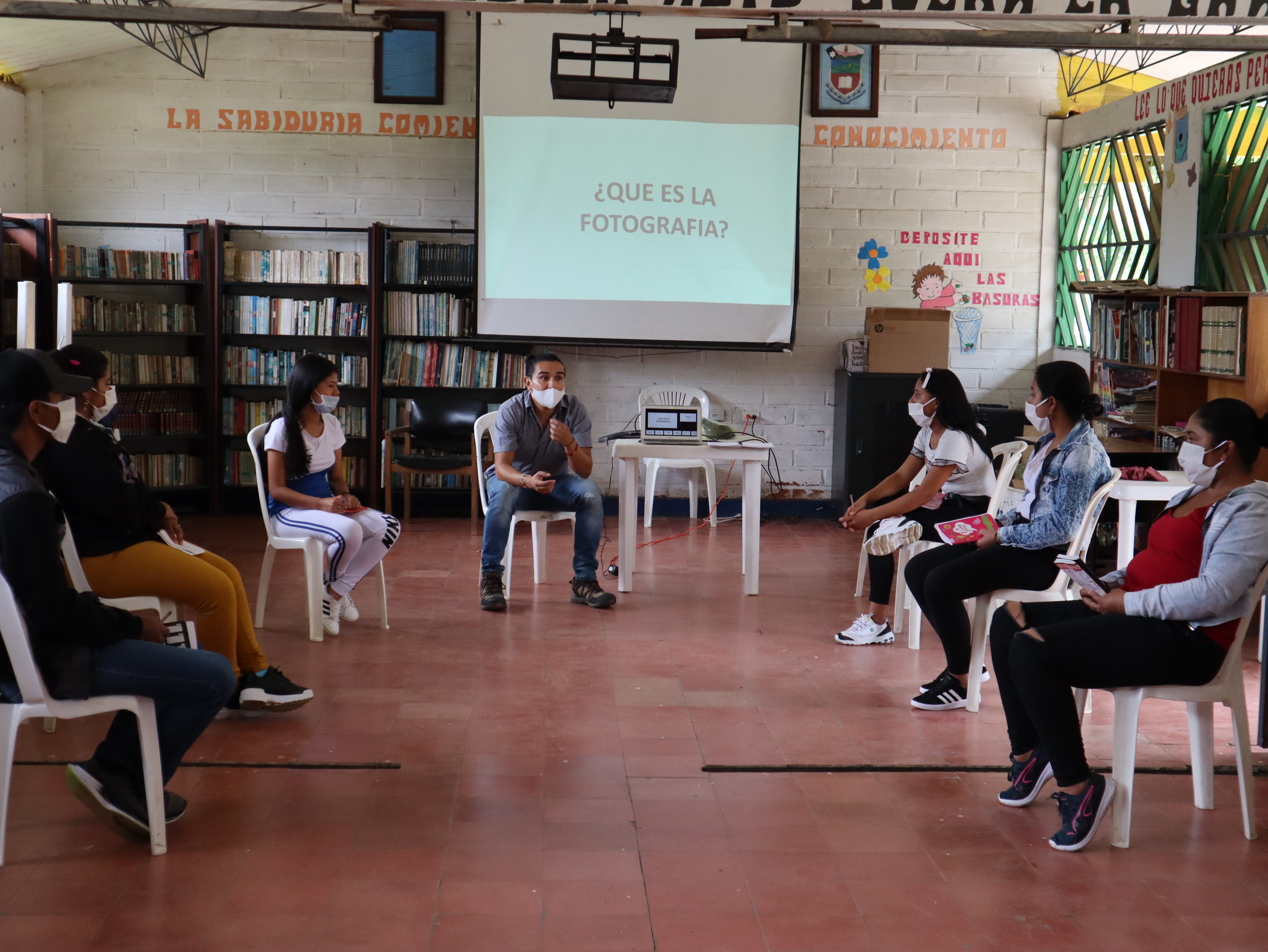 Unas personas están sentadas, escuchando un taller de fotografía.