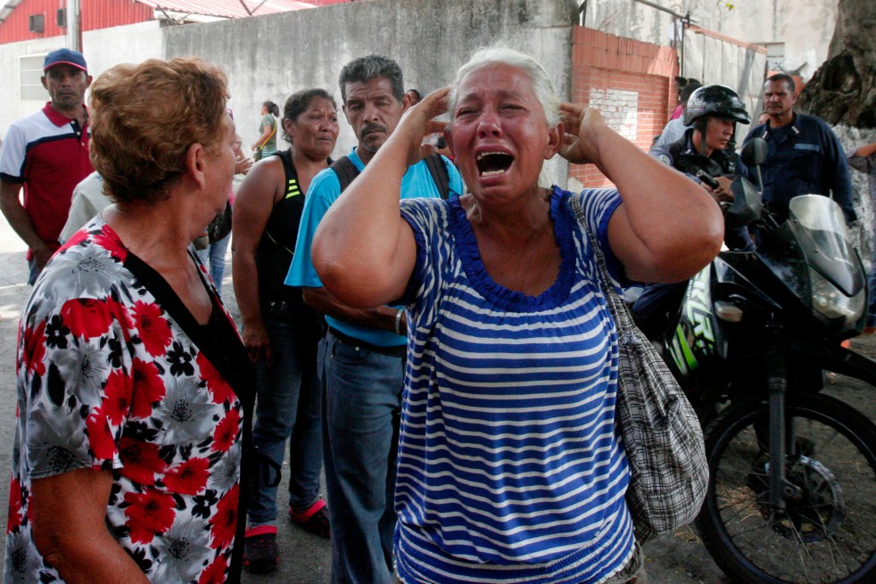 Familiares de reclusos de la prisión de Carabobo buscan información tras el motín e incendio que dejaron 68 muertos. / AFP