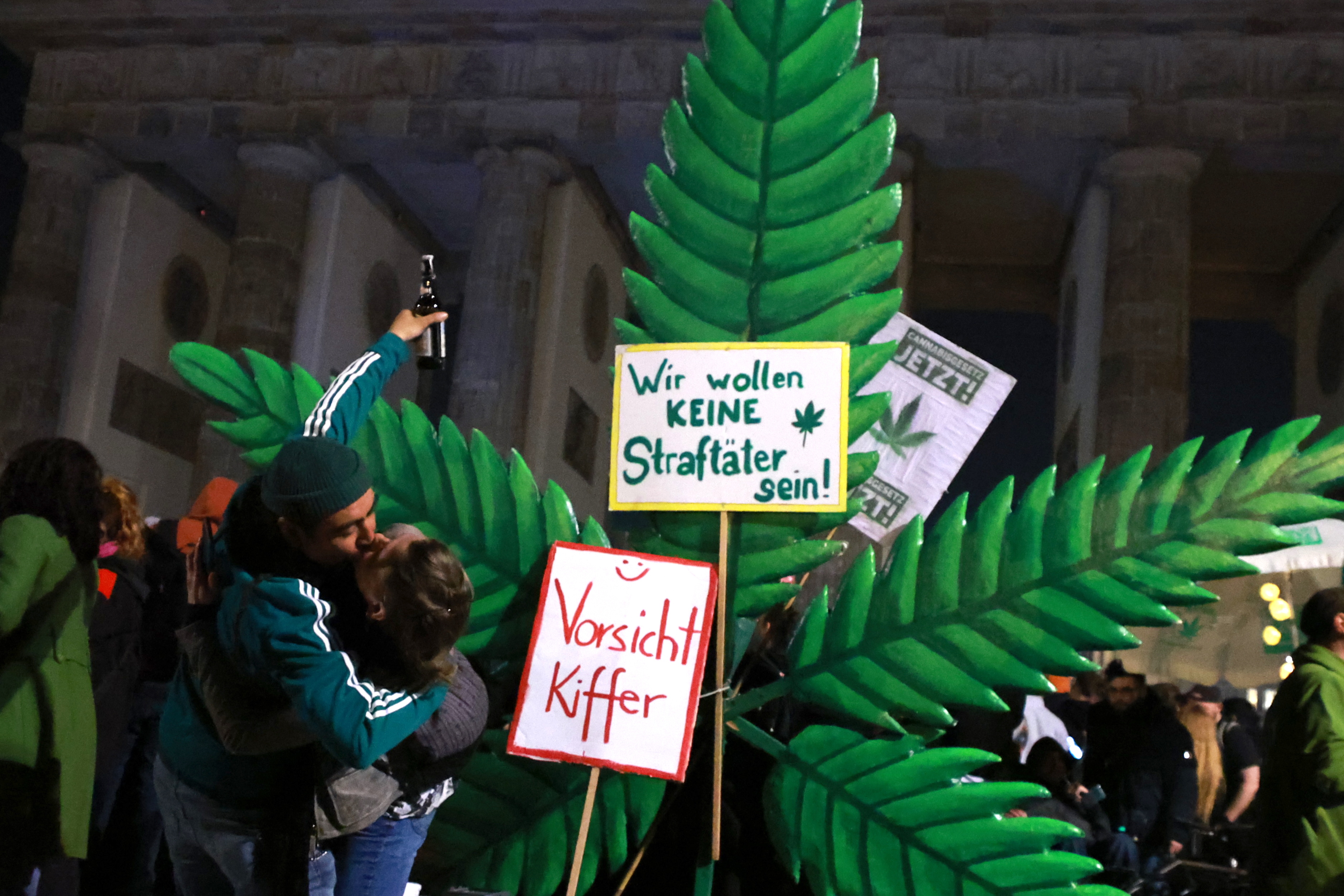 Berlin (Germany), 31/03/2024.- Participants kiss in front of a giant hemp leaf at the Brandenburg Gate on the occasion of a so called 'Smoke-In' event in Berlin, Germany, 01 April 2024. Activists and supporters welcomed a new status of law, regarding the use of cannabis, in Germany. The German Federal Council 'Bundesrat' on 22 March approved a law decriminalizing the recreational usage of cannabis in Germany for adults age 18 and over. Starting 01 April 2024 it will be legal for adults in Germany to possess up to 50 grams of dried cannabis at home and up to 25 grams in public for personal use. The law allows growth and distribution only in cultivation associations also called Cannabis Social Clubs and comes into force on 01 July 2024. People can purchase cannabis for recreational use if they are members of those specific clubs but cannot consume it in the premises. (Alemania) EFE/EPA/CLEMENS BILAN