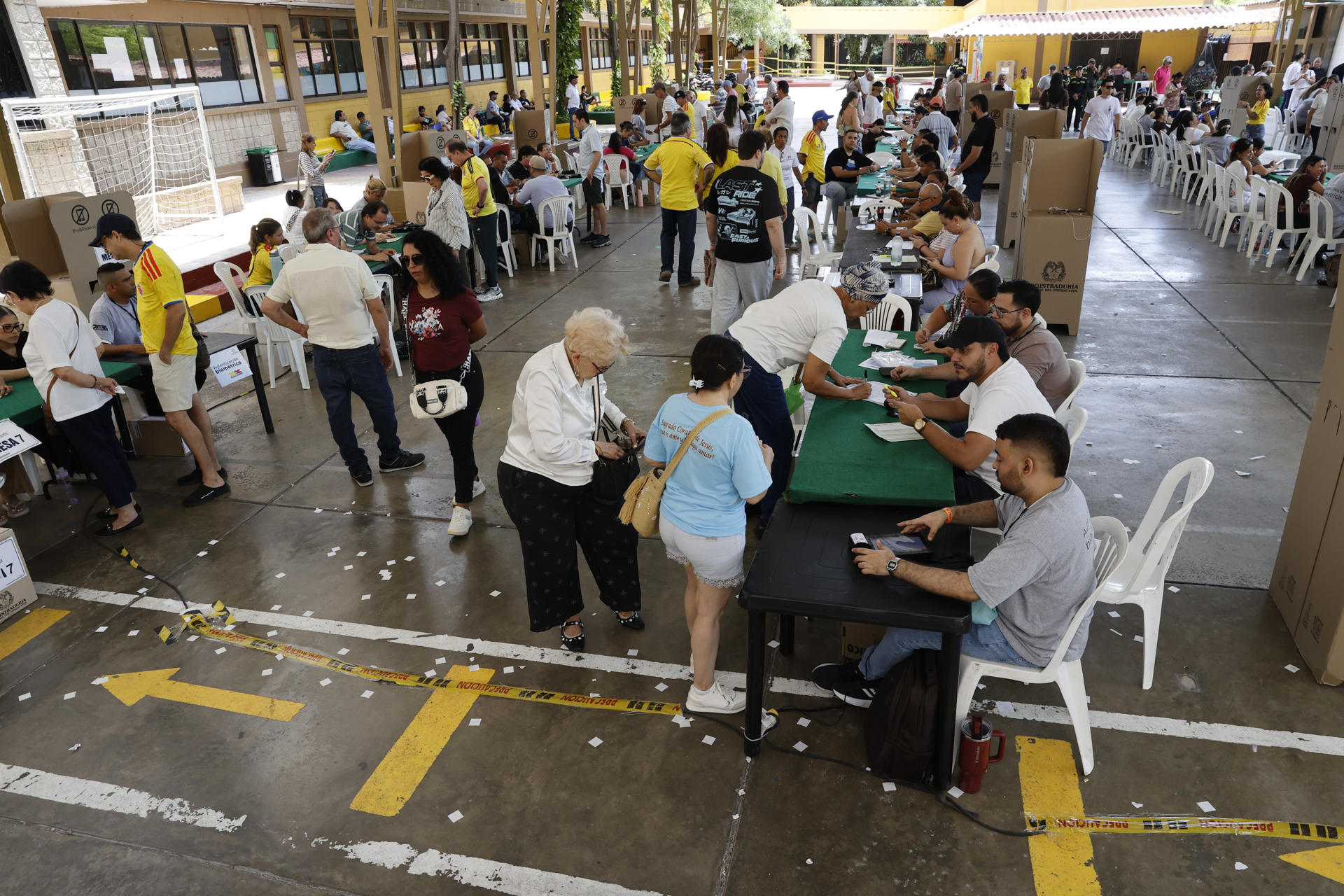 AME2985. BARRANQUILLA (COLOMBIA), 21/06/2026.- Personas asisten a votar durante la segunda vuelta de las elecciones presidenciales este domingo, en Barranquilla (Colombia). La elección del sucesor del presidente colombiano, Gustavo Petro, avanza sin incidentes, en una jornada en la que el candidato de ultraderecha Abelardo de la Espriella y el izquierdista Iván Cepeda ya votaron y llamaron a los indecisos a apoyarlos para ganar. EFE/ Mauricio Dueñas Castañeda
