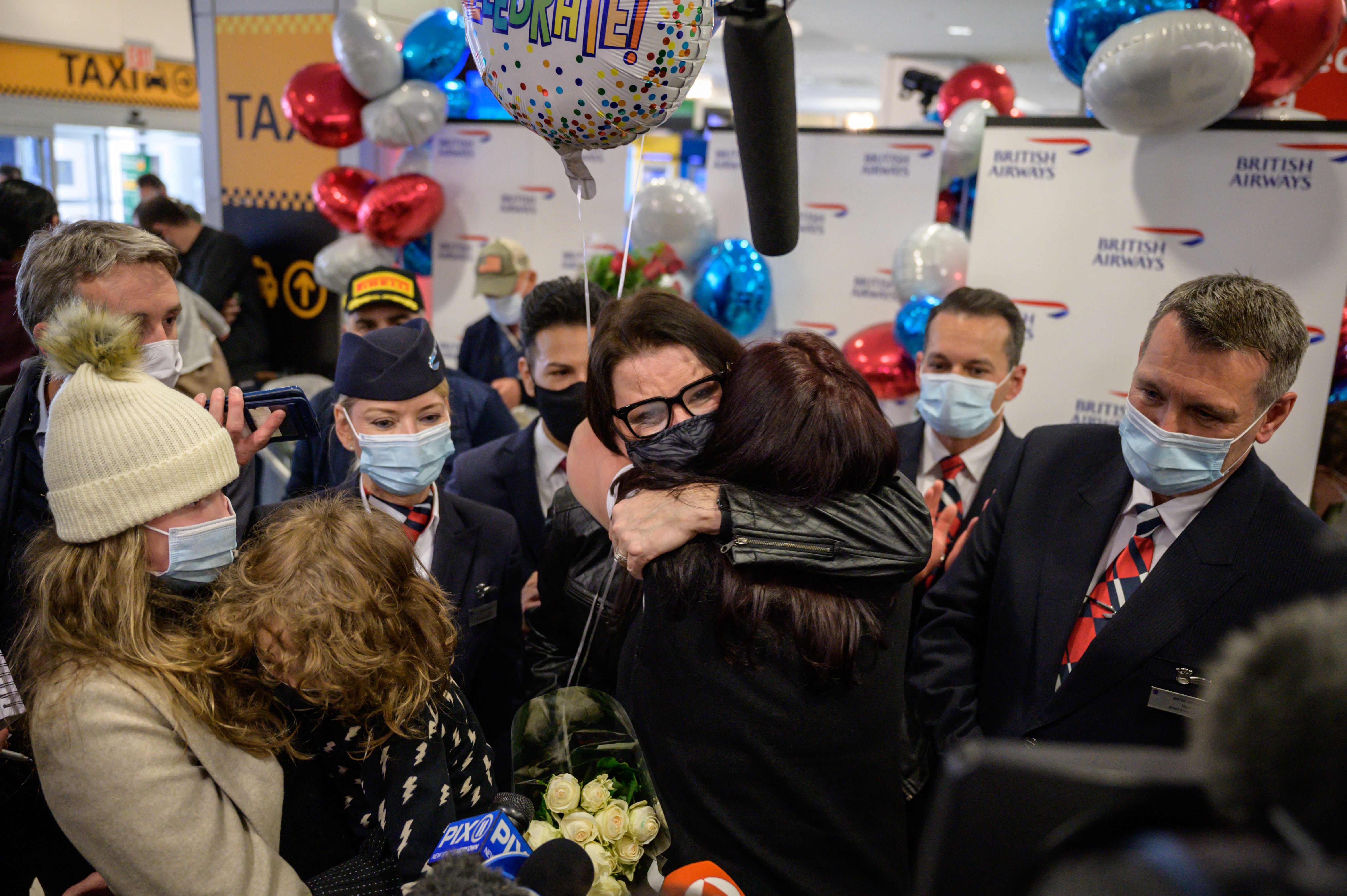 Los miembros de la familia Erebara se abrazan después de llegar en un vuelo desde el Reino Unido, en el aeropuerto internacional JFK en Nueva York.