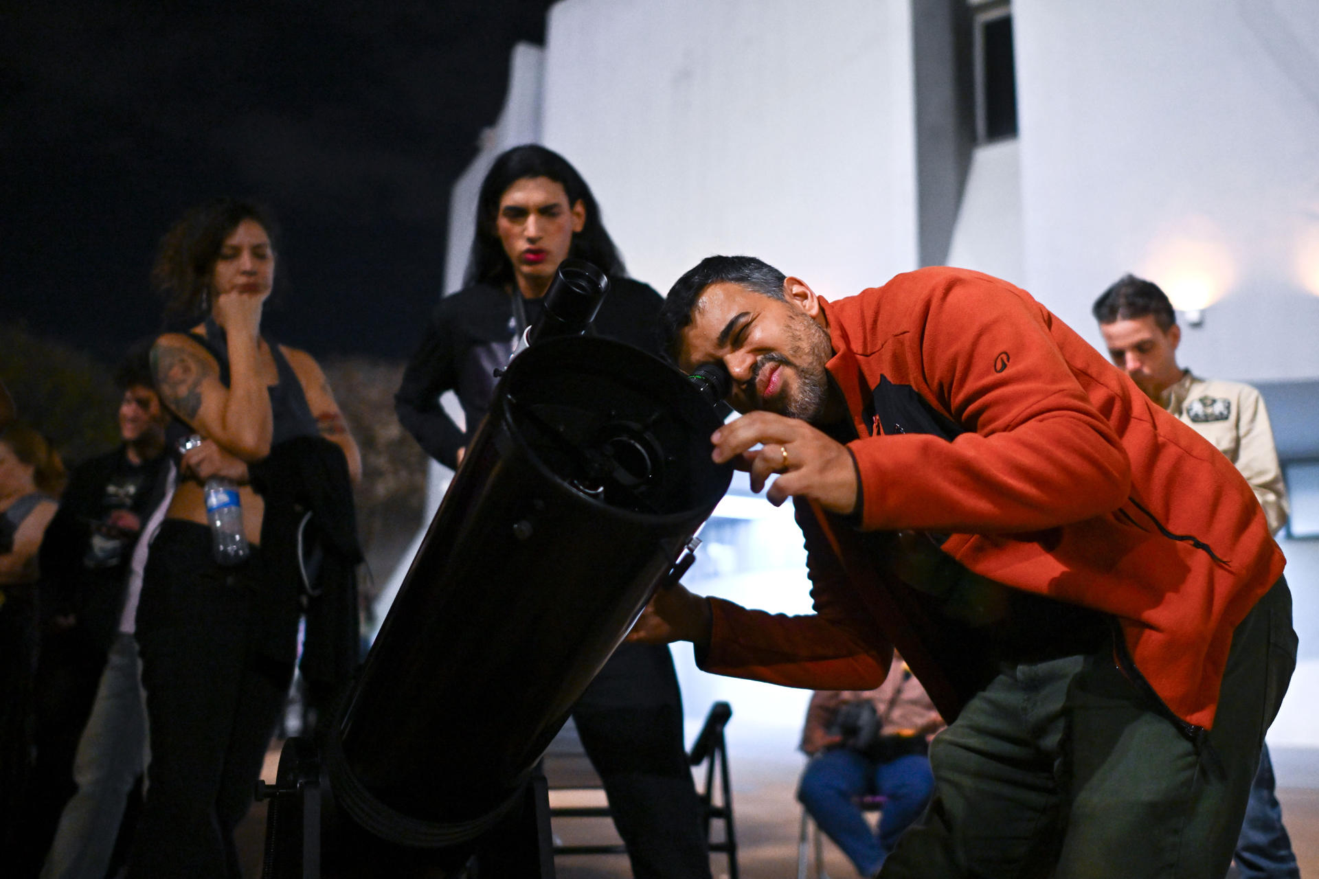 Una persona observa en un telescopio la luna llena durante el eclipse lunar parcial este jueves, en el Planetario de Brasilia.
