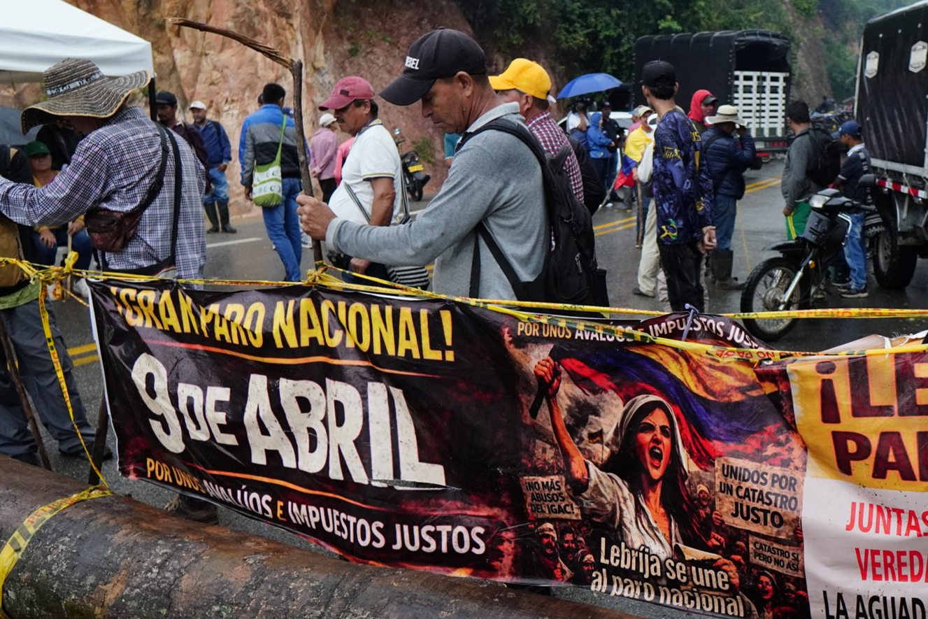 AME3154. LEBRIJA (COLOMBIA), 13/04/2026.- Personas participan en una manifestación para rechazar el incremento de los avalúos catastrales de sus propiedades, este lunes en la carretera que conduce al Aeropuerto Internacional Palonegro, en Lebrija (Colombia). EFE/ Marco Valencia
