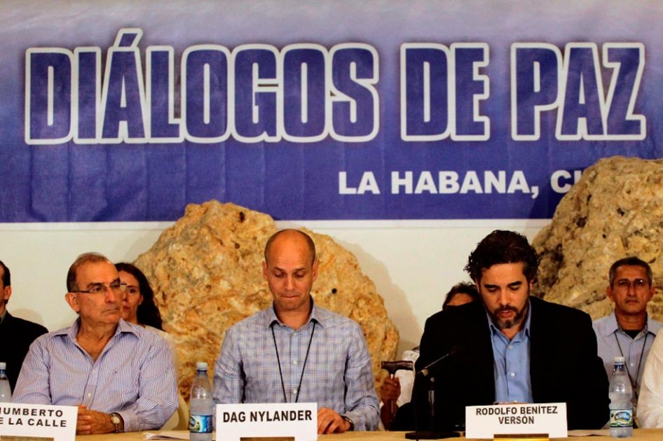 Los delegados de los países garantes (Cuba y Noruega) leen uno de los comunicados conjuntos elaborados por los negociadores del Gobierno y las Farc.  / AFP