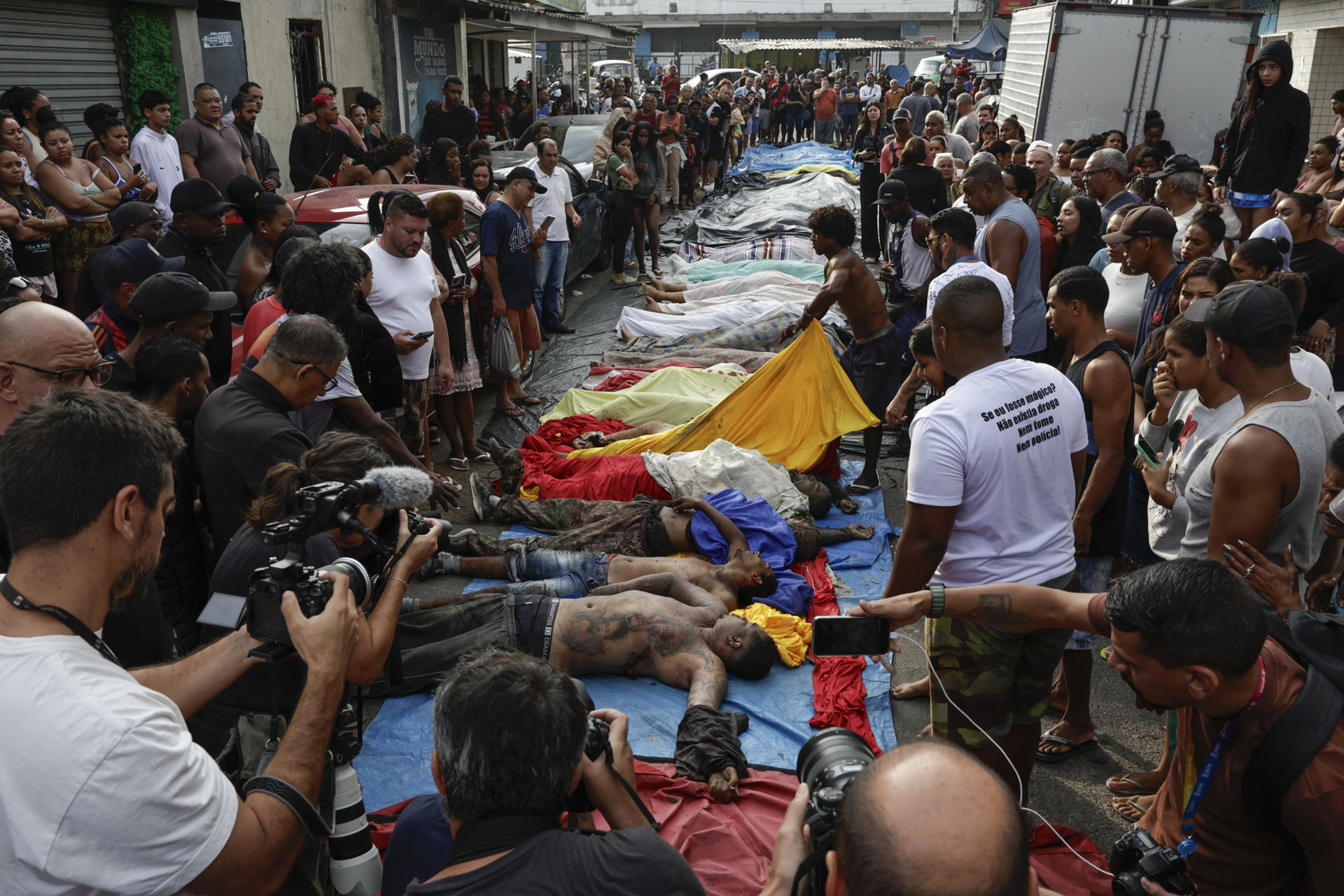 ATENCIÓN EDITORES: CONTENIDO GRÁFICO EXPLICITO ACOMPAÑA CRÓNICA: BRASIL DROGAS AME3085. RÍO DE JANEIRO (BRASIL), 29/10/2025.- Personas observan cuerpos sin vida en una calle este miércoles, en Río de Janeiro (Brasil). El megaoperativo del martes, en el que participaron 2.500 agentes, tenía como objetivo detener a cabecillas del Comando Vermelho, una de las organizaciones criminales mas antiguas y peligrosas de Rio. EFE/ André Coelho