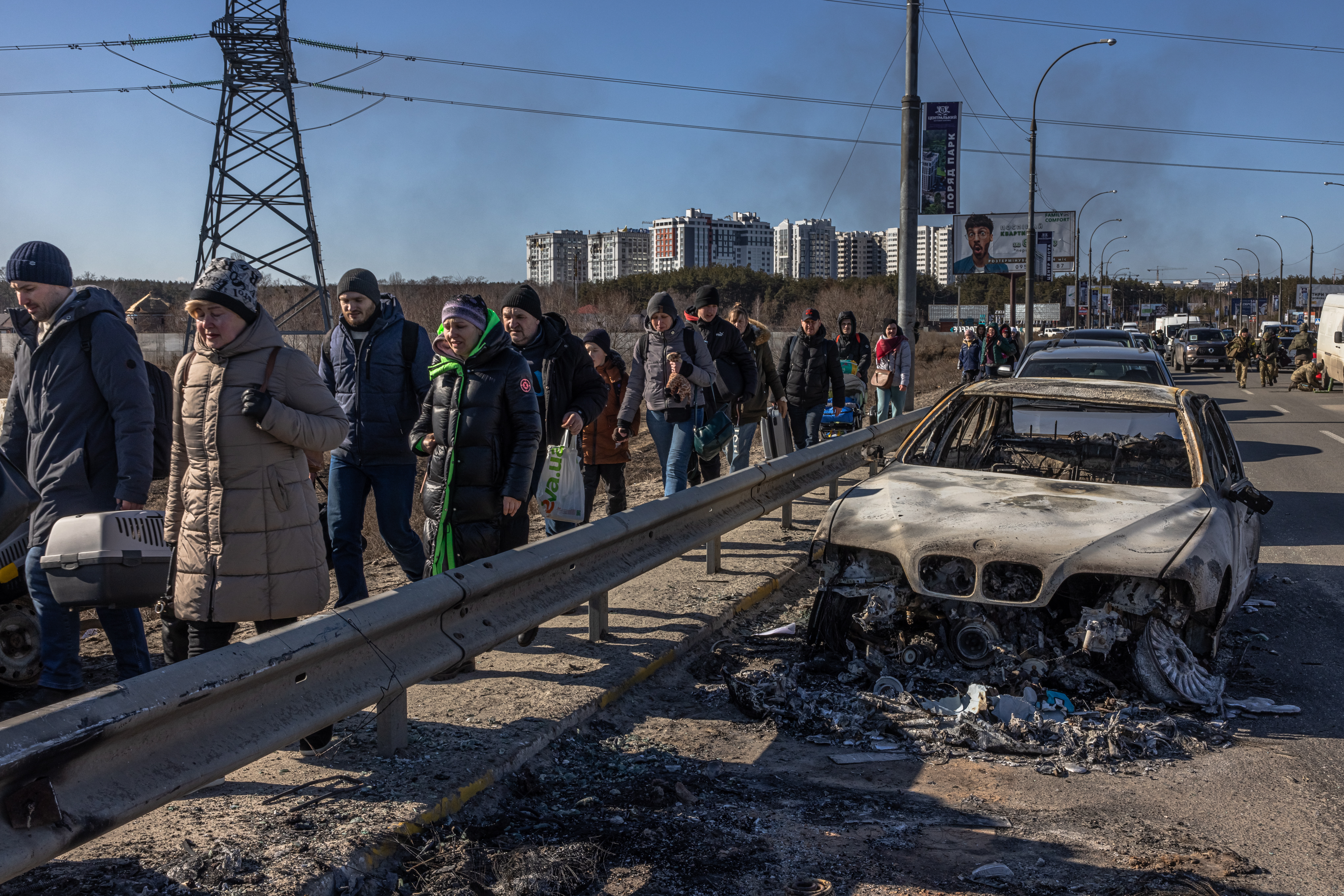 Kyiv (kiev) (Ukraine), 10/03/2022.- Residents walk past a burnt car as they flee from the frontline town of Irpin, Kyiv (Kiev) region, Ukraine, 10 March 2022. Thousands of residents are feeling Irpin and Bucha, as well as other settlements near Kyiv which were the most affected by the Russian army invasion. (Rusia, Ucrania, Estados Unidos) EFE/EPA/ROMAN PILIPEY