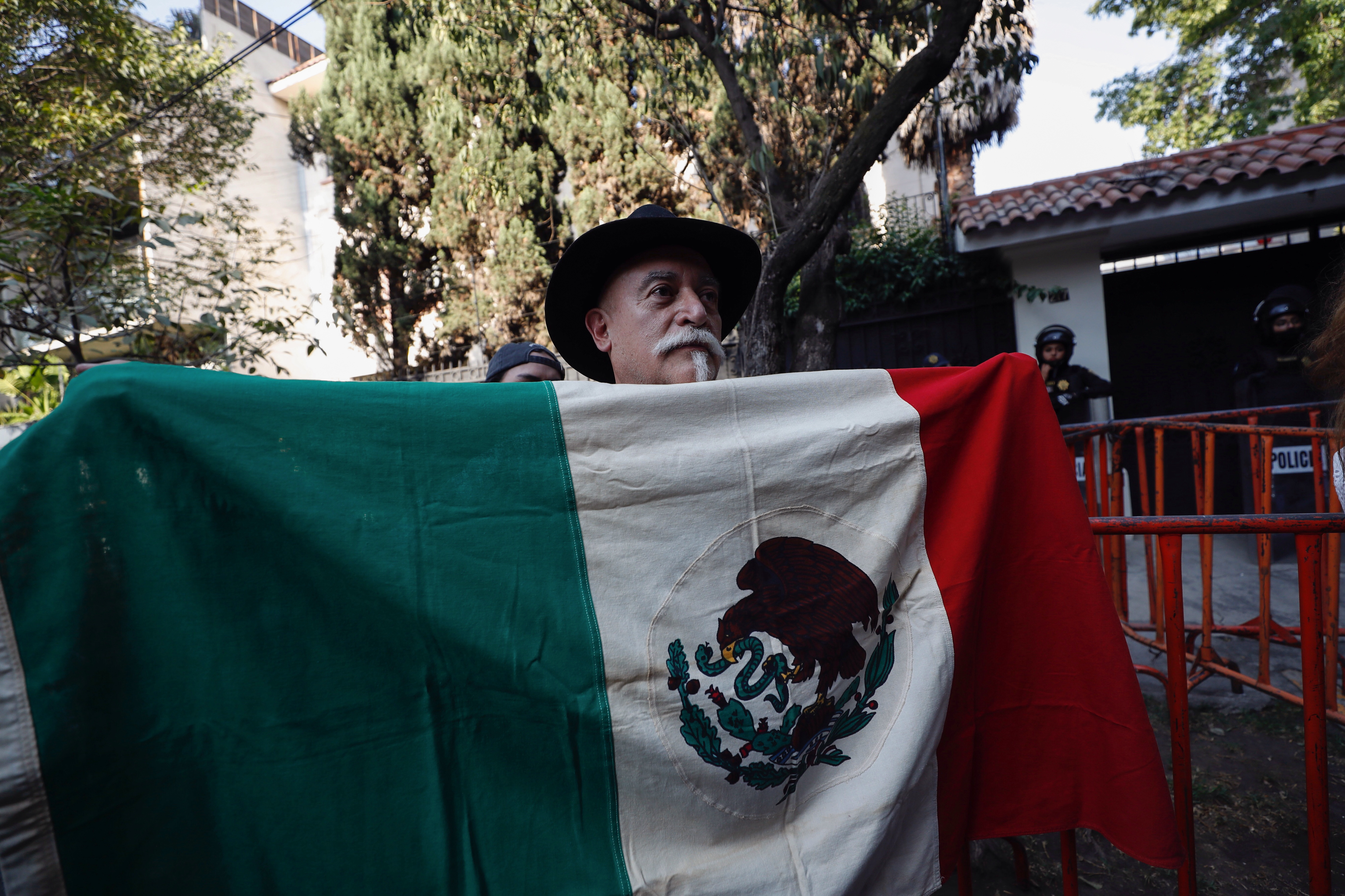 MEX3645. CIUDAD DE MÉXICO (MÉXICO), 06/04/2024.- Un hombre sostiene la bandera de México durante una protesta afuera de la Embajada de Ecuador este sábado, en la Ciudad de México (México). México vivió este sábado entre el asombro y la indignación la escalada de tensiones con Ecuador tras el asalto a la Embajada en Quito, mientras el presidente, Andrés Manuel López Obrador, hizo llamados a prudencia y agradeció la solidaridad de numerosos países latinoamericanos. EFE/Sáshenka Gutiérrez