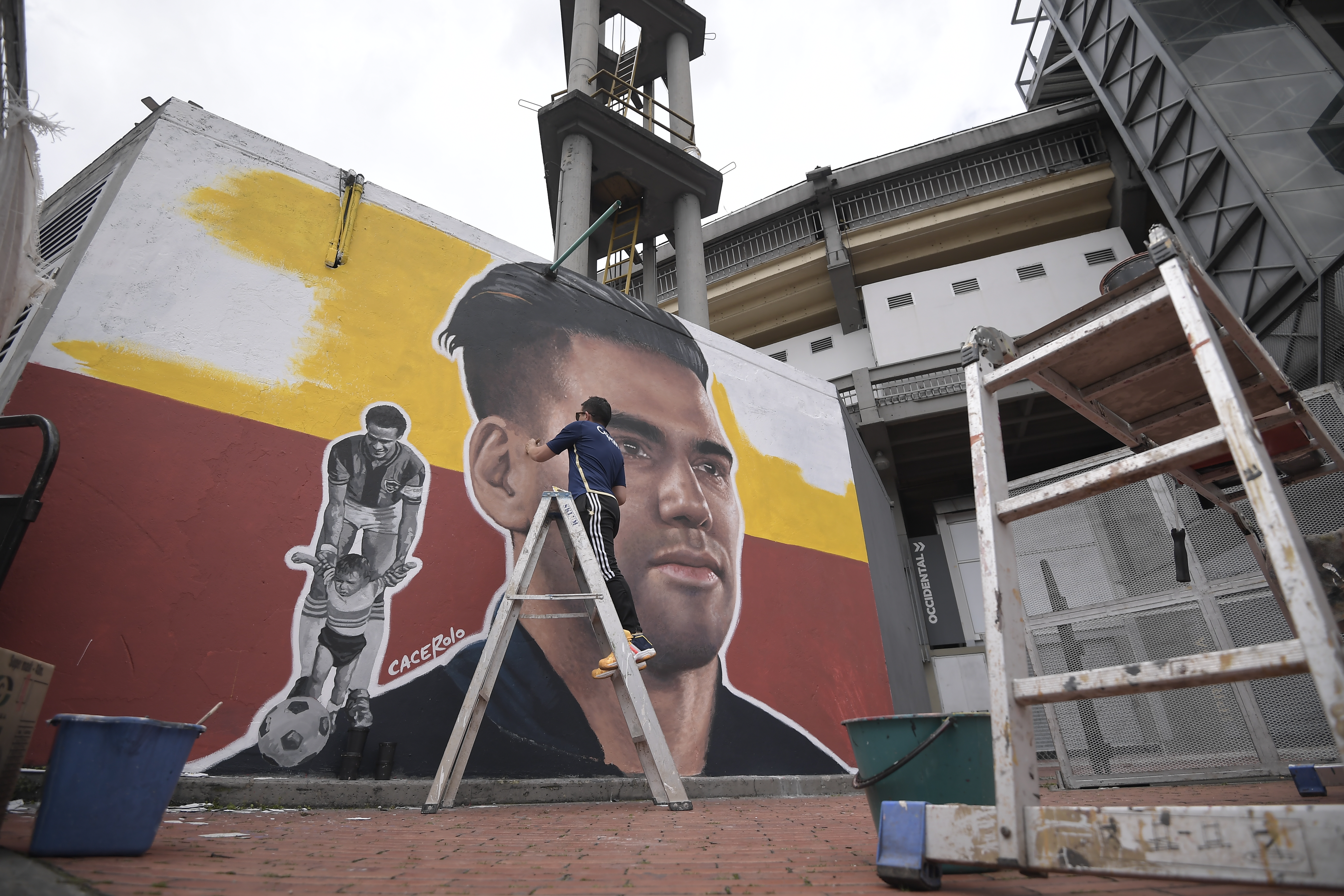 Artista conocido como "Cacerolo", pinta un mural con el rostro del futbolista colombiano Radamel Falcao García, en una de las paredes del exterior del estadio Nemesio Camacho ' El Campín', este martes en Bogotá (Colombia).