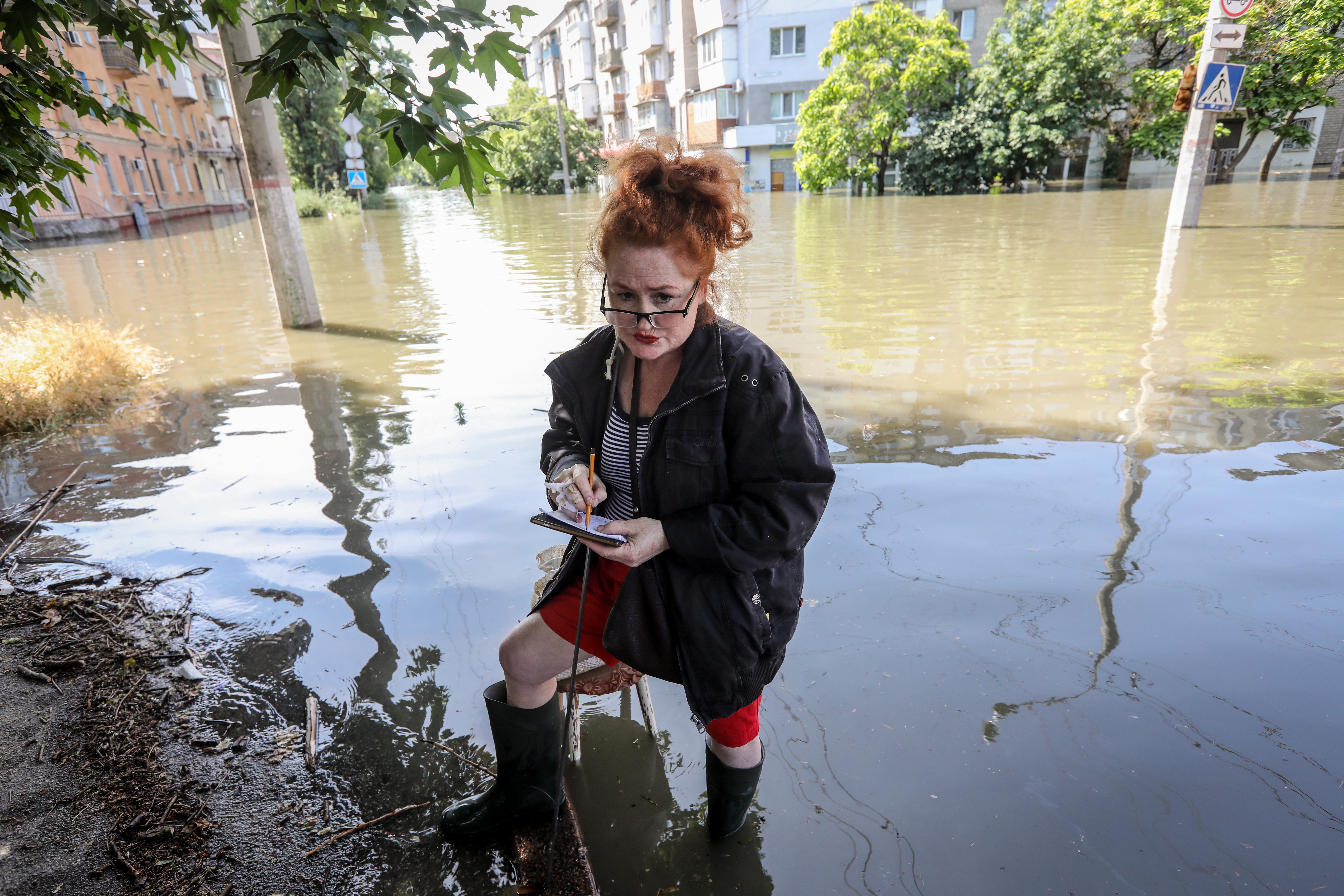 Kherson (Ukraine), 07/06/2023.- A woman stands in a flooded street of Kherson, Ukraine, 07 June 2023. Ukraine has accused Russian forces of destroying a critical dam and hydroelectric power plant on the Dnipro River in the Kherson region along the front line in southern Ukraine on 06 June. A number of settlements were completely or partially flooded, Kherson region governor Oleksandr Prokudin said on telegram. Russian troops entered Ukraine in February 2022 starting a conflict that has provoked destruction and a humanitarian crisis. (Rusia, Ucrania) EFE/EPA/MYKOLA TYMCHENKO