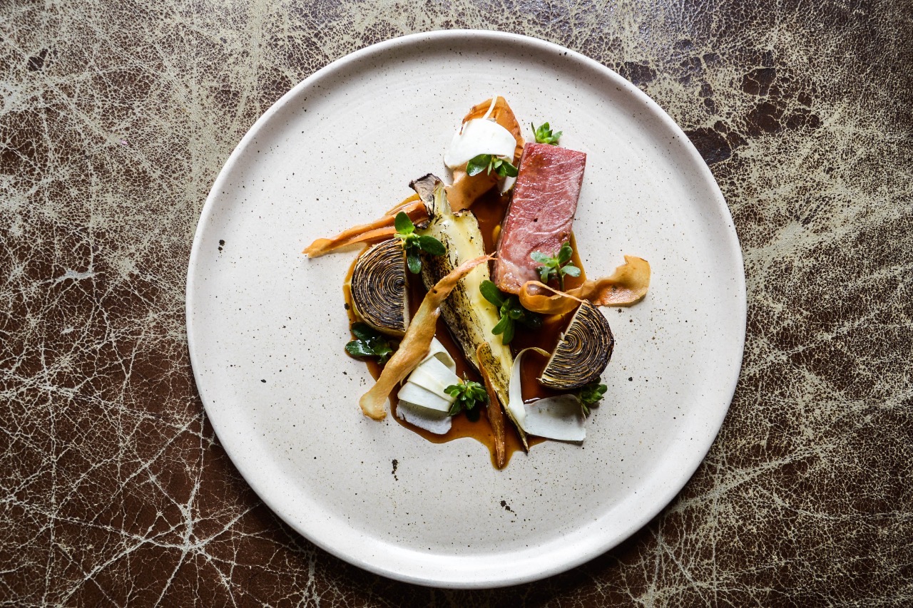¿Y las ideas para emplatar?El emplatado del restaurante ha logrado un estilo único que, de echo varios periodistas y críticos me lo han preguntado bastante por estos días porque normalmente siempre tiendo a esconder cosas que tiene el plato. La única respuesta que tengo es que el cliente de Bogotá me dio este estilo, ya que muchas veces la gente dejaba cosas a un lado. Por ejemplo, tenemos un plato de corazones de pollo que lleva acederas y la gente siempre las dejaba a un lado. Este estilo de emplatado hace que si la gente quiere el corazón tiene que pasar si o si por la acedera.
