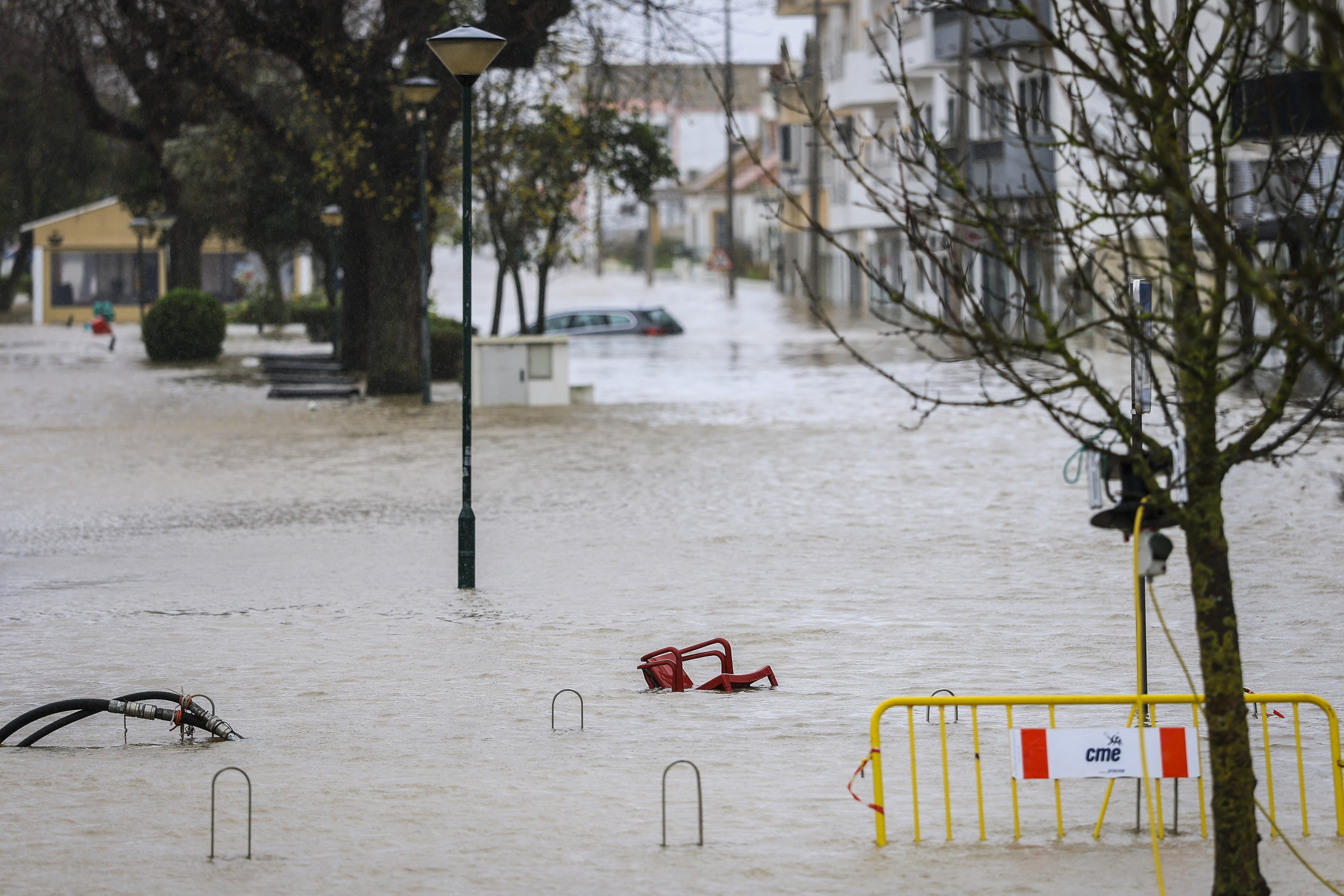 Chairs are pictured floating in a flooded street of Alcacer do Sal, south of Portugal, during Leonardo storm on February 4, 2026. The Iberian peninsula on February 4, 2026 braced for a violent storm, with southern Spain shutting schools and Portugal placed on fresh alert after severe weather killed five people last week. (Photo by PATRICIA DE MELO MOREIRA / AFP)