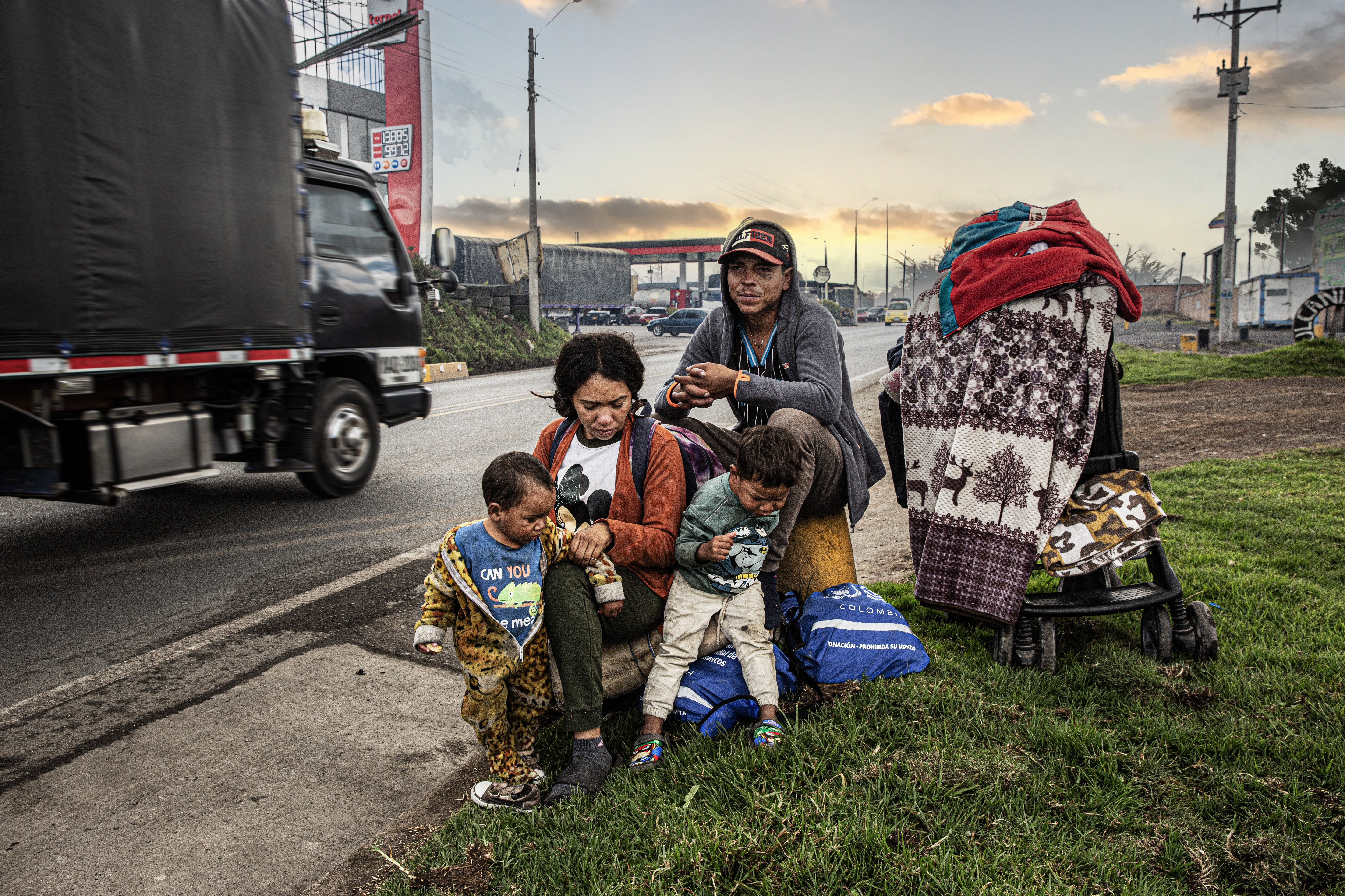 Migrantes sobre la carretera Panamericana, en Nariño, Colombia, esperan que algún carro o camión los acerque a la próxima ciudad.