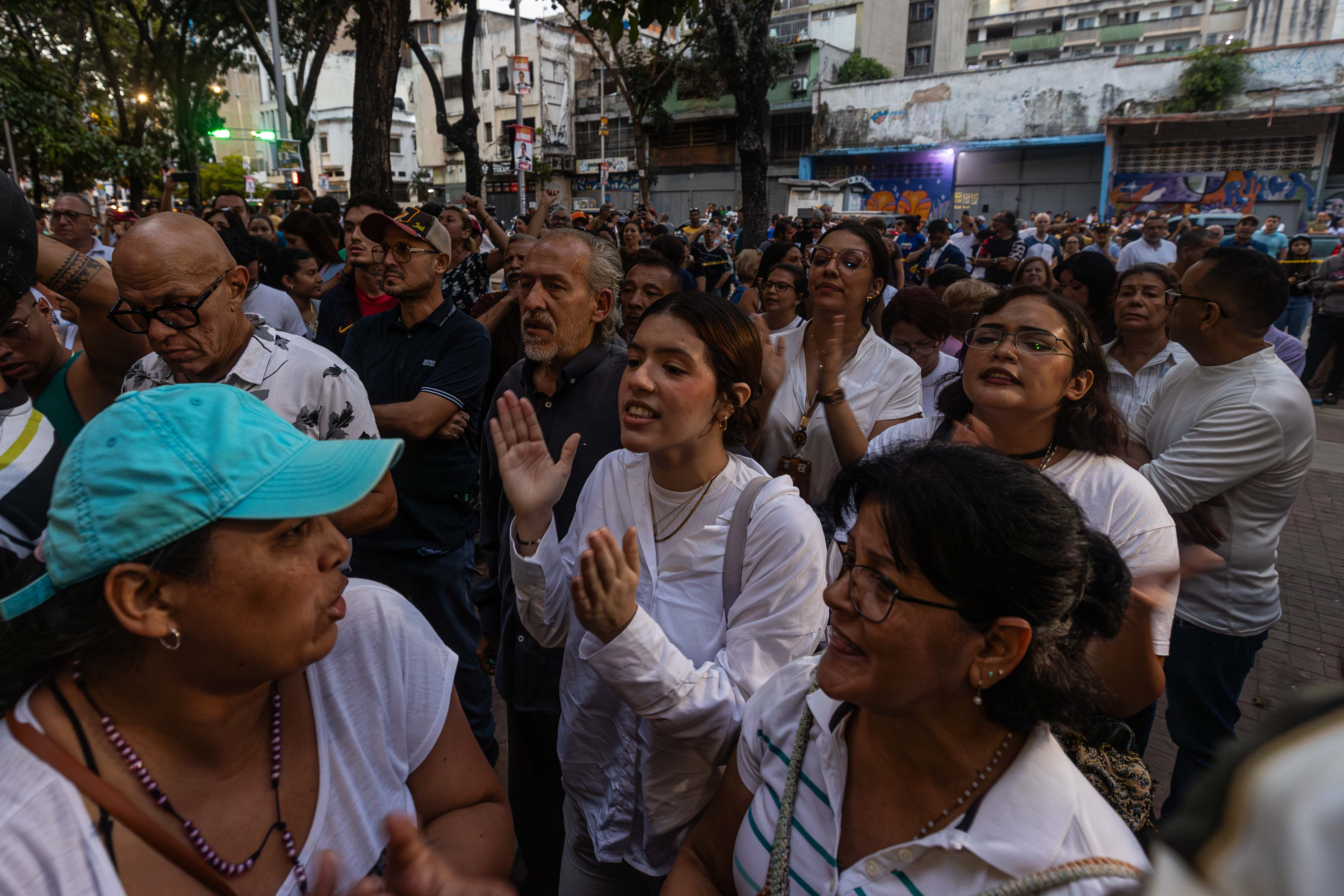 AME6011. CARACAS (VENEZUELA), 28/07/2024.- Ciudadanos esperan los resultados de las elecciones presidenciales este domingo, afuera de un centro de votación en Caracas (Venezuela). Varias decenas de motorizados que se identificaron como chavistas llegaron a un centro de votación en Caracas, donde se encontraban testigos opositores y ciudadanos que esperaban el comienzo del escrutinio de las elecciones presidenciales de este domingo, lo que dio lugar a una confrontación que acabó a golpes, ante la mirada impasible de los policías, que no intervinieron para detener la pelea. EFE/ Henry Chirinos