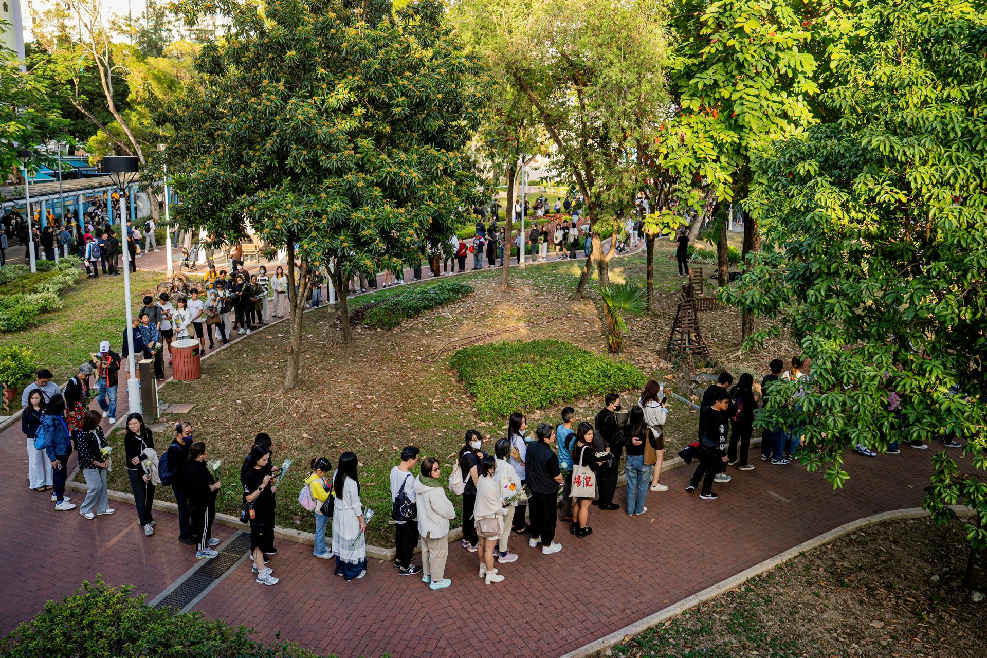 HONG KONG (China), 29/11/2025.- People lay floral tributes for the victims of the fire at the Wang Fuk Court residential estate in the Tai Po district of Hong Kong, China, 29 November 2025. The city is mourning 128 people killed in the high-rise apartment fire, with about 200 others still unaccounted for. EFE/EPA/LEUNG MAN HEI