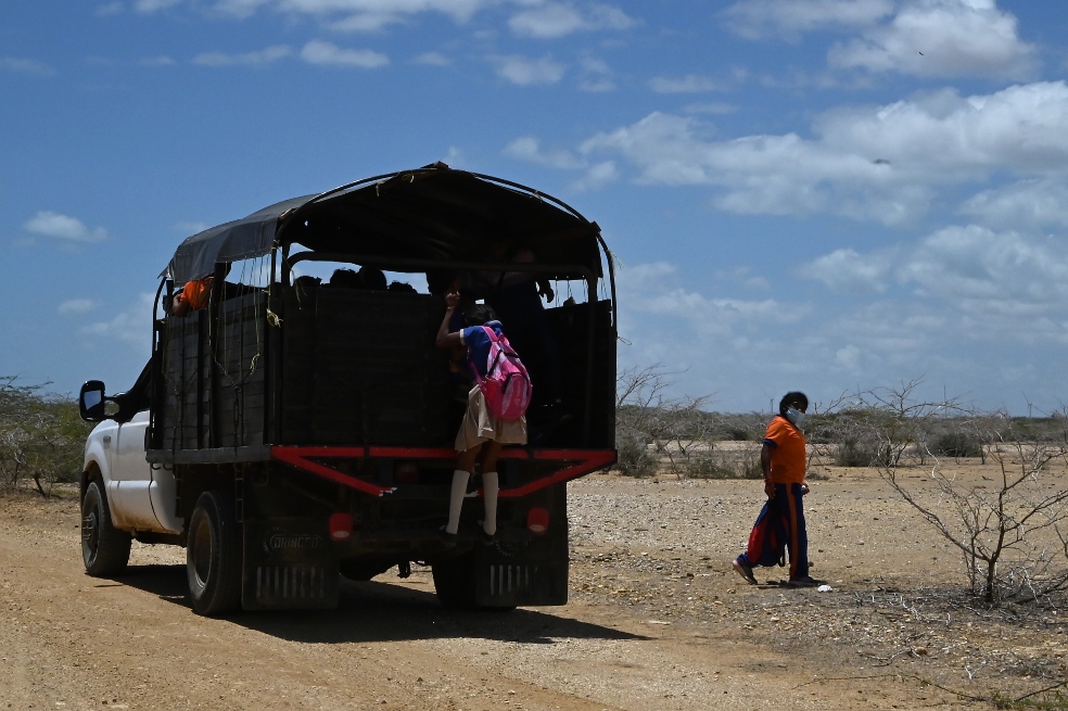 Un camión de transporte escolar oficial, contratado por el Estado, deja a dos estudiantes cerca de su casa.