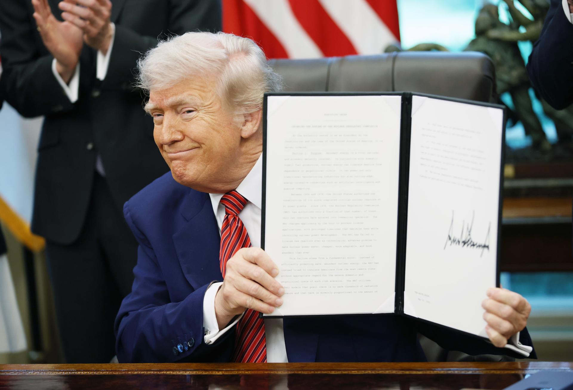 WASHINGTON (United States), 23/05/2025.- US President Donald Trump holds up an executive order on nuclear energy in the Oval Office of the White House, Washington, D.C., USA, 23 May 2025. He signed a total of five executive orders aimed at easing restrictions and expanding the nuclear energy industry. EFE/EPA/SAMUEL CORUM / POOL
