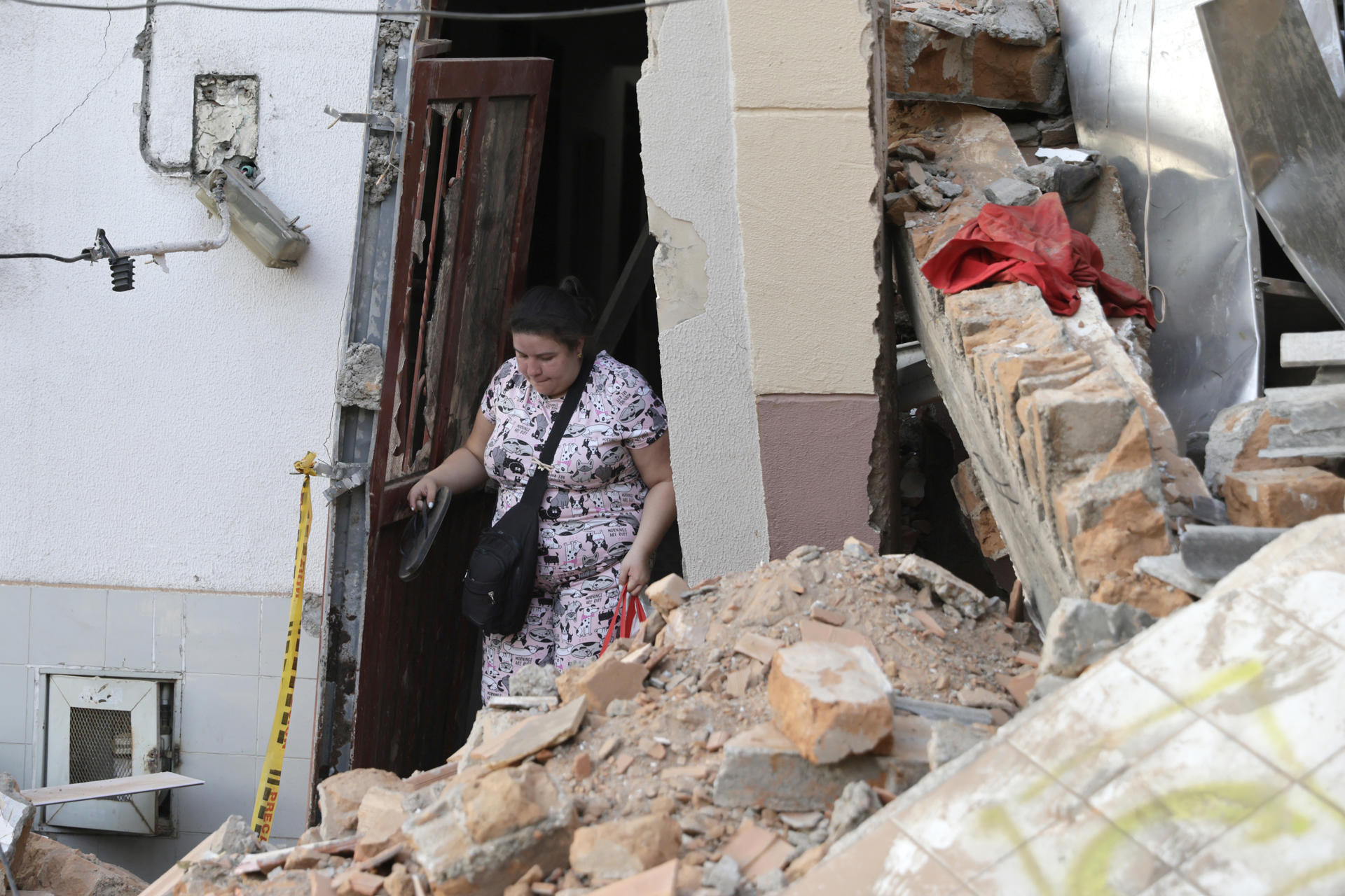 AME7989. PEREIRA (COLOMBIA), 11/08/2026.- Una mujer camina entre los escombros de una vivienda este martes, en el sector de Corocito en Pereira (Colombia). Colombia concentró sus esfuerzos en la búsqueda de supervivientes, la atención a los damnificados y la evaluación de los daños tras el terremoto de magnitud 7,4 que sacudió el lunes varias regiones del país y que ha causado hasta el momento centenares de muertos y miles de viviendas afectadas. EFE/ Carlos Ortega
