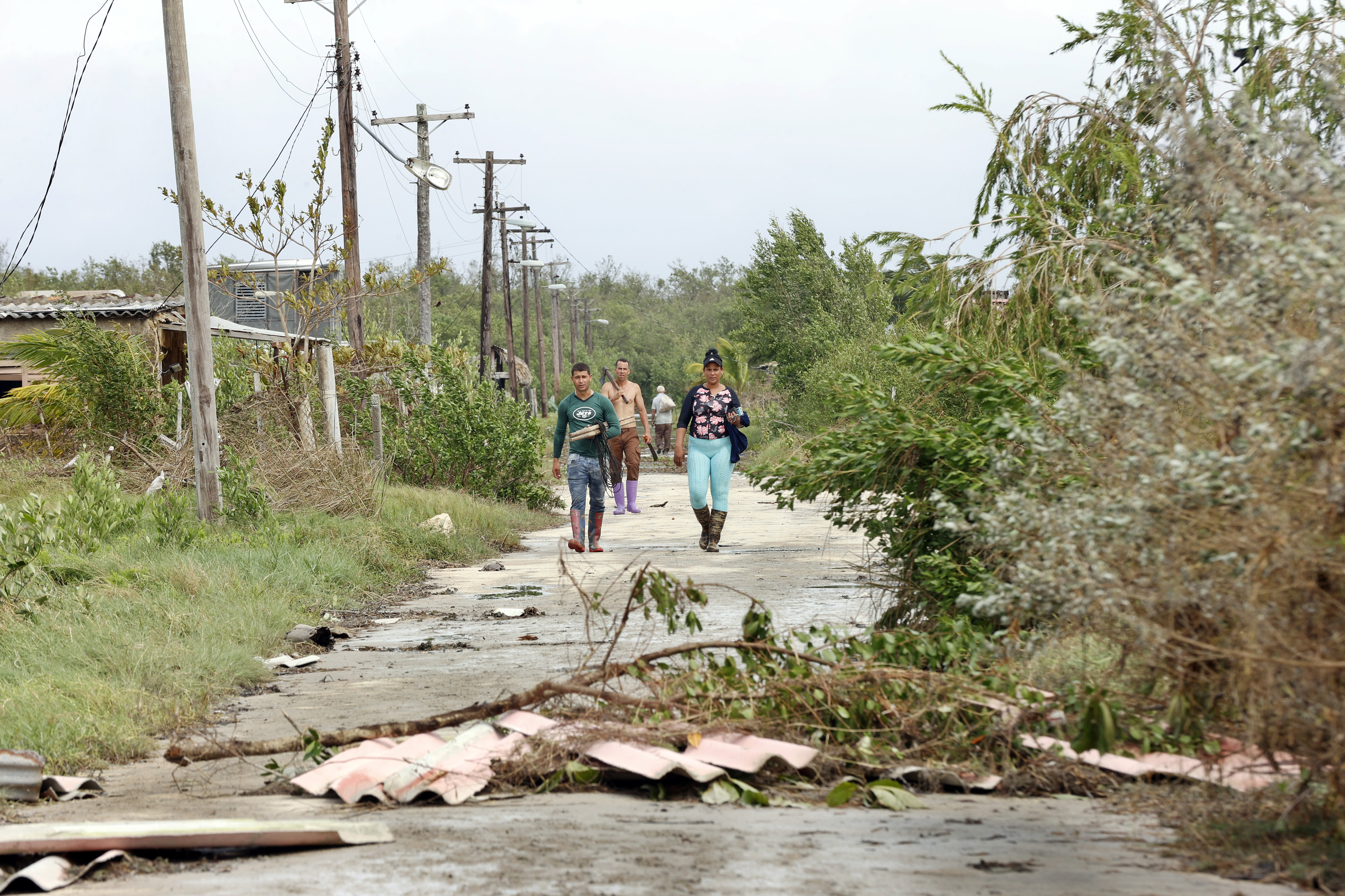 Unas personas caminan por una calle afectada tras el paso del huracán Rafael, en Playa Majana. El pronóstico de la NOAA es que Rafael se mueva sobre el centro del Golfo de México este fin de semana y principios de la próxima semana.