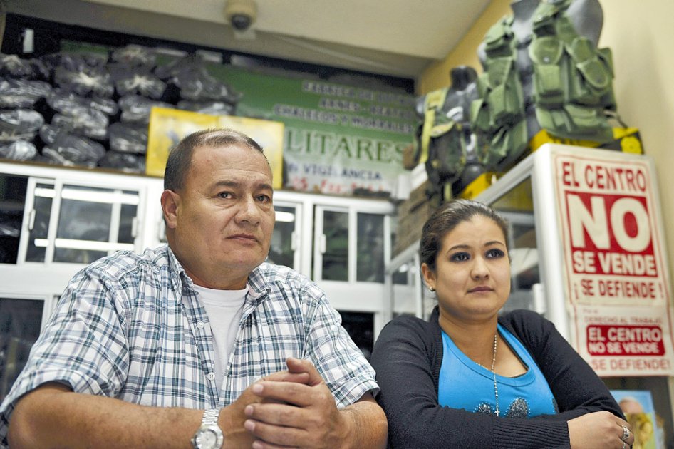Fredy Garzón, propietario de un almacén de artículos militares, y su hija Lady, líder de “El centro no se vende”. / Fotos: Andrés Torres - El Espectador