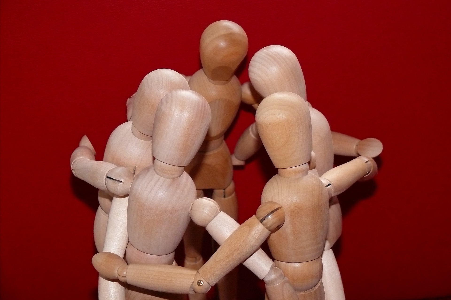 Imagen de muñecos de madera abrazados, simulando unión.