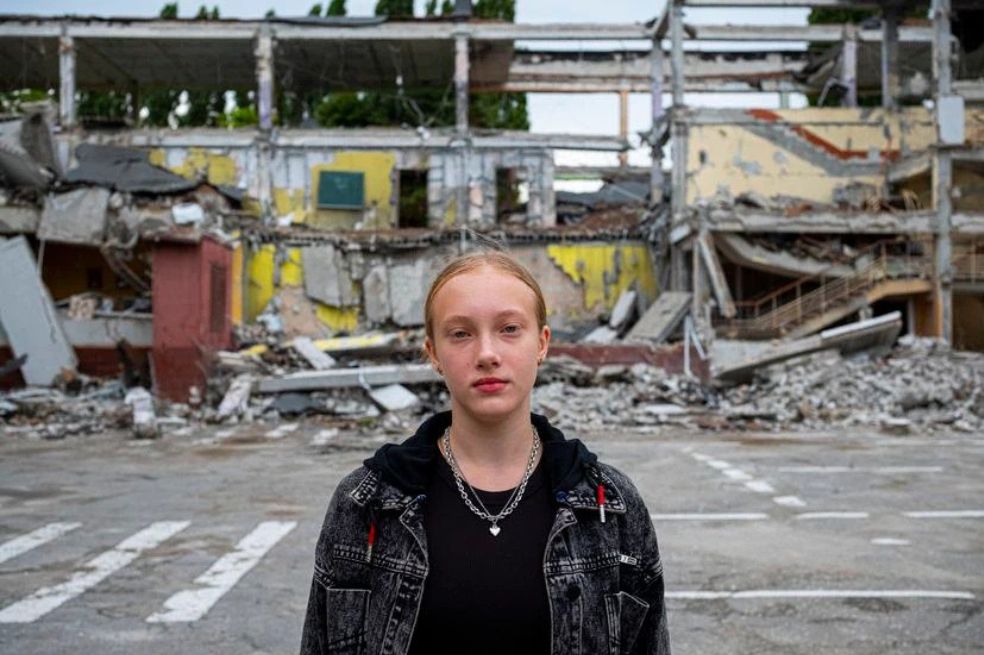 De 12 años, la estudiante está en frente de la escuela en donde iba a tomar clases este año. Ahora, Mariia tendrá clases en línea.