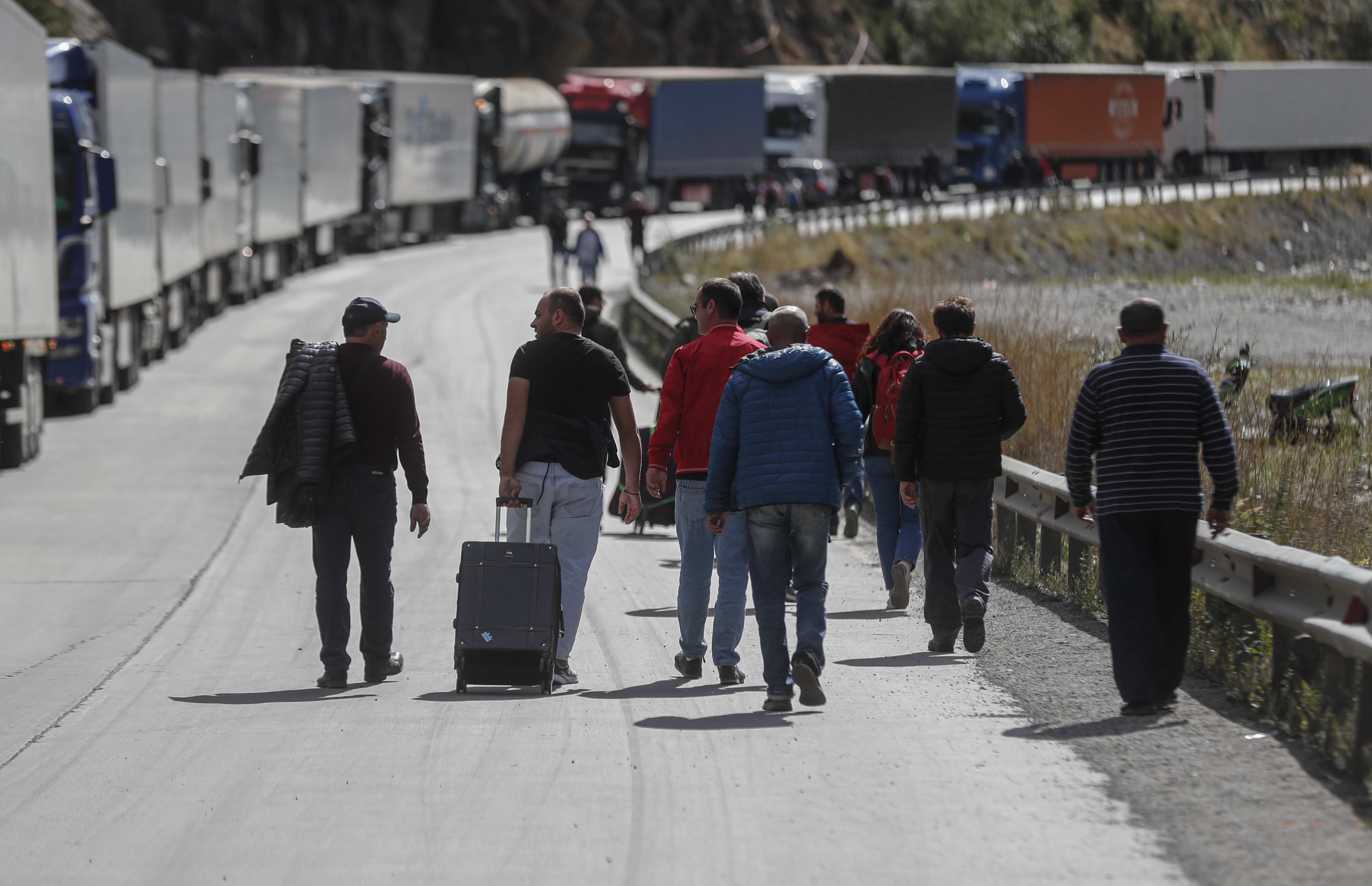 Verkhnii Lars (Georgia), 27/09/2022.- Russian men with their luggage walk along a road after passing through customs at the Georgia-Russia border checkpoint of Verkhnii Lars, Georgia, 27 September 2022. Thousands of Russian men left Russia after Russian President Putin announced in a televised address to the nation on 21 September, that he signed a decree on partial mobilization in the Russian Federation due to the conflict in Ukraine. Russian Defense Minister Shoigu said that 300,000 people would be called up for service as part of the move. Georgian Interior Minister Vakhtang Gomelauri said on 27 September, that in recent days some 10,000 Russians have crossed the border with Georgia every day. On 24 February 2022 Russian troops entered the Ukrainian territory in what the Russian president declared a 'Special Military Operation', starting an armed conflict that has provoked destruction and a humanitarian crisis. (Rusia, Ucrania, Estados Unidos) EFE/EPA/ZURAB KURTSIKIDZE