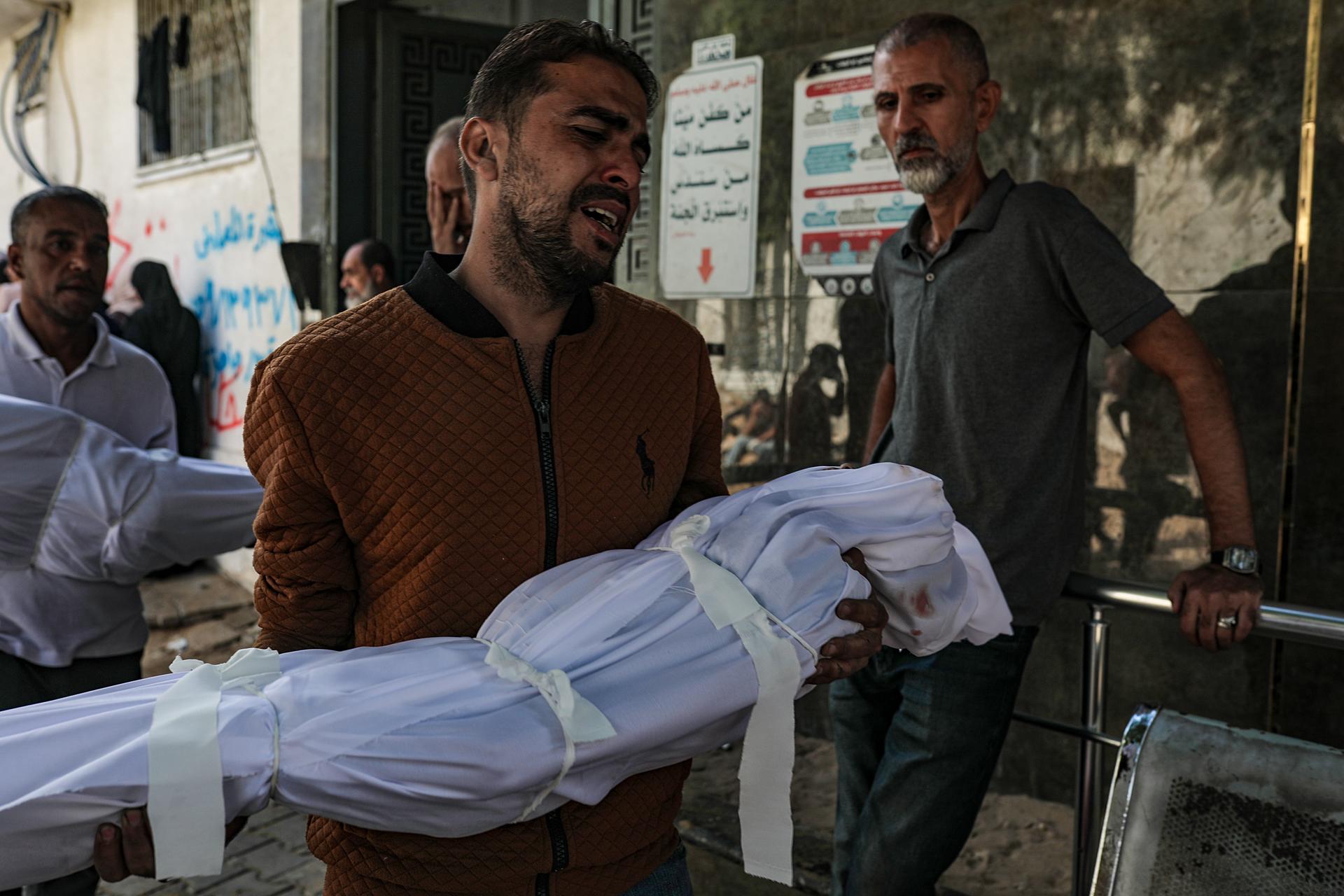 GAZA CITY (---), 29/10/2025.- Mahmoud Shakshak, 36, carries the body of one of his two children Fady, 5, and Sara, 8, at Al Shatea refugee camp in Gaza City, 29 October 2025. Fady and Sarah Mahmoud Shakshak were killed in an Israeli air strike in Al Shatea refugee camp in Gaza. According to the Palestinian Ministry of Health in Gaza, at least 110 Palestinians were killed and many others wounded in Israeli air strikes on the Gaza Strip. EFE/EPA/MOHAMMED SABER