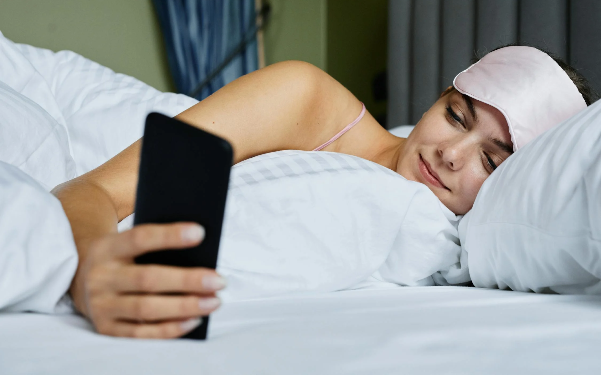 Mujer revisando el celular al despertar.