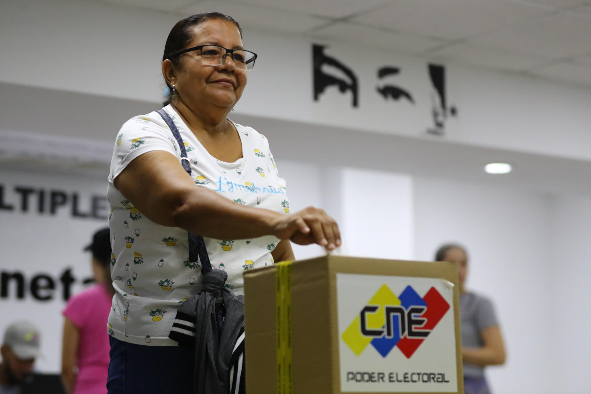 AME2899. CARACAS (VENEZUELA), 27/04/2025.- Una mujer introduce su voto en una urna durante una consulta popular este domingo, en Caracas (Venezuela). Venezolanos acuden a los centros de votación para participar en la segunda consulta popular del año, promovida por el chavismo, en la que 5.338 comunidades registradas escogerán proyectos financiados por el Estado. EFE/ Ronald Peña R.