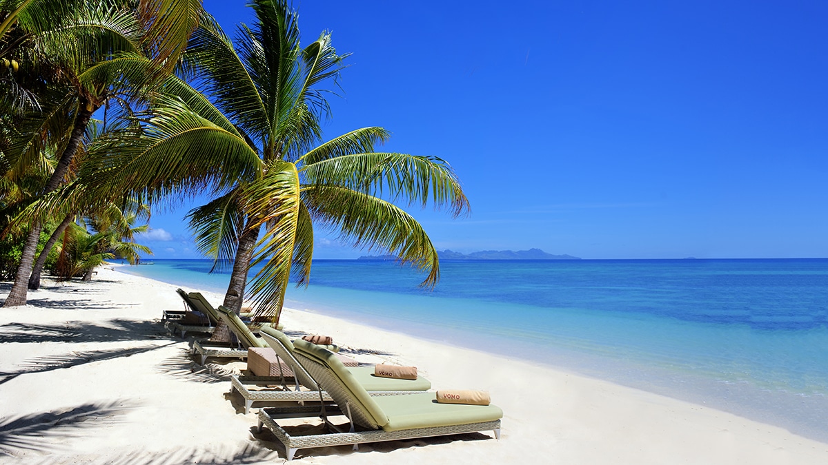 East Beach es uno de esos destinos donde la naturaleza parece permanecer intacta. Ubicada en la isla privada de Vomo, en el archipiélago de las Mamanucas, en Fiji, esta playa se distingue por su arena blanca, aguas tranquilas y un entorno rodeado de palmeras y vegetación exuberante. Su ubicación resguardada la convierte en un lugar ideal para nadar durante todo el día, mientras su escaso desarrollo turístico permite disfrutar de largos tramos prácticamente en soledad.