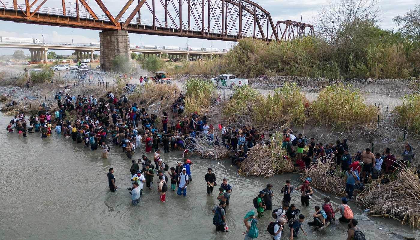 VIDEO Con cobijas, migrantes libran el último obstáculo hacia EU: la alambrada de púas