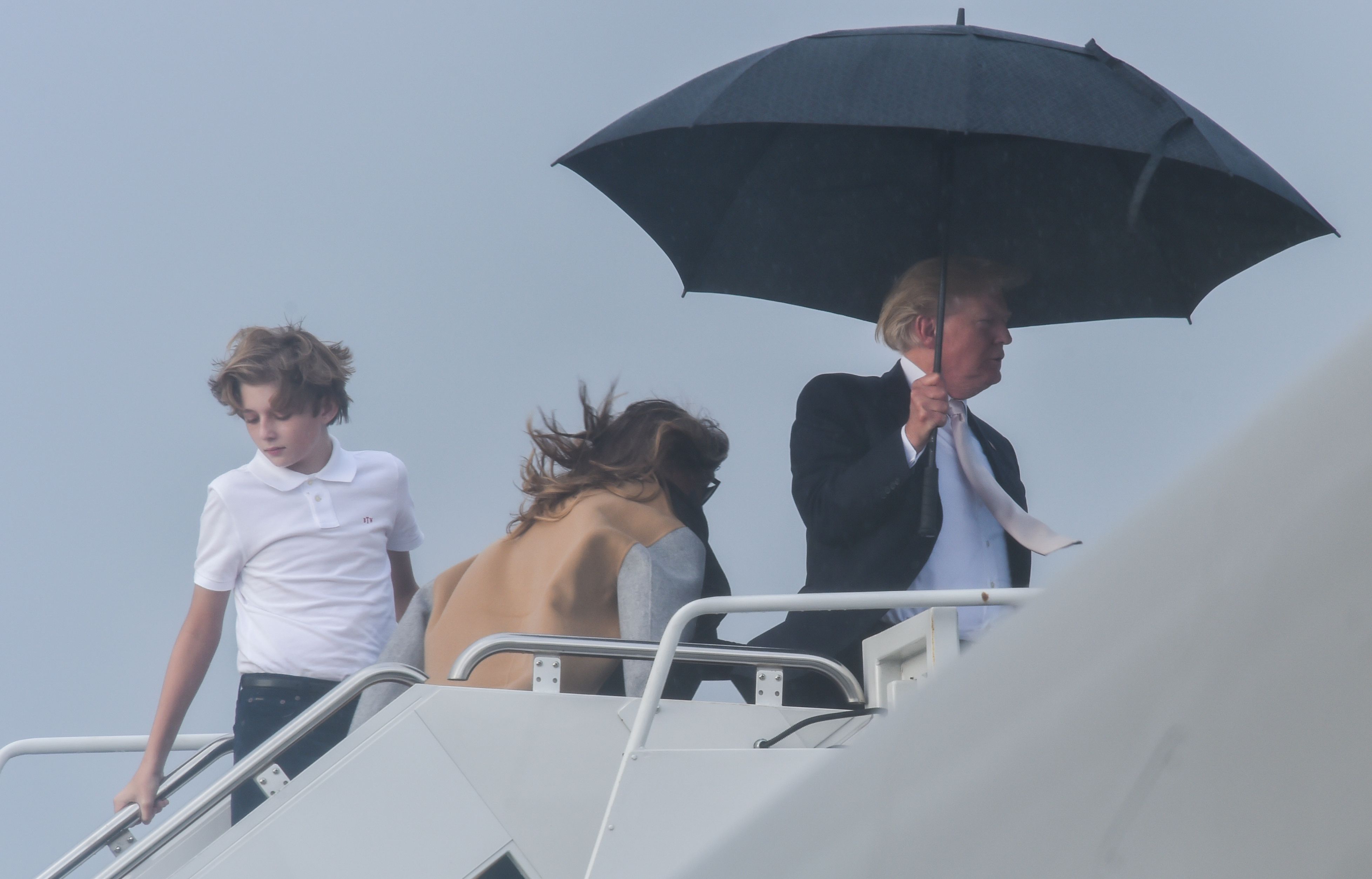 Video. Trump se cubre con paraguas mientras Melania y su hijo se mojan