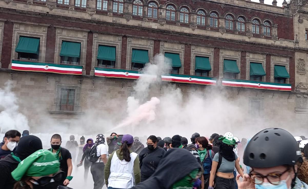 Feministas derriban vallas de Palacio Nacional; policía responde con humo de extintores