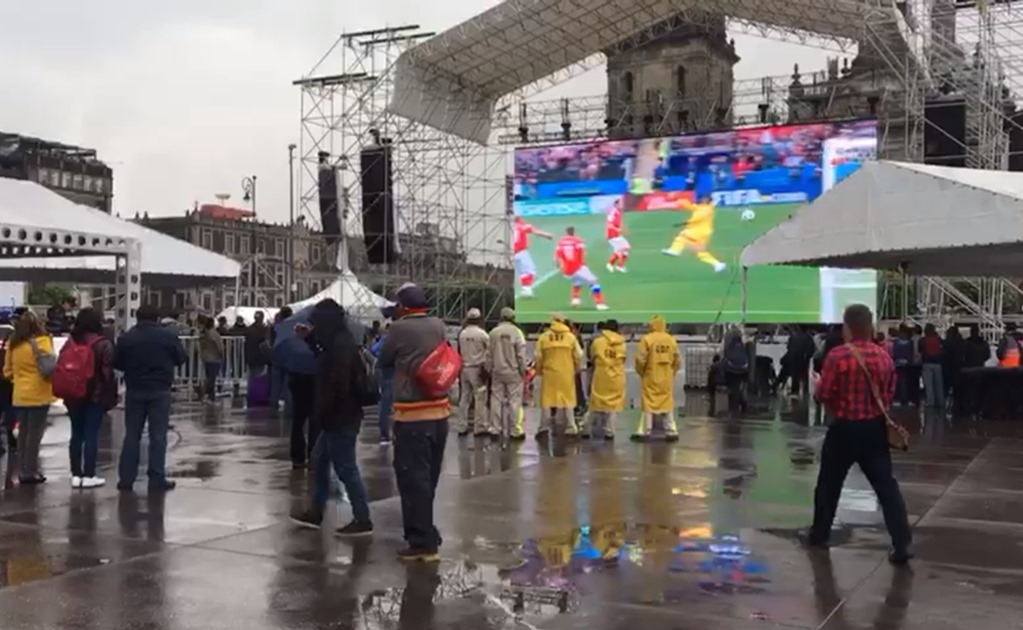 Bajo la lluvia, capitalinos acuden a transmisión del Mundial en el Zócalo