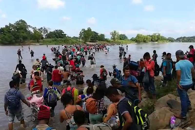 Caravana migrante cruza a pie el río que separa a Guatemala de México