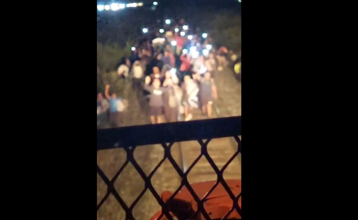 VIDEO Con celulares y sobre las vías, migrantes orillan a conductor de tren a detenerse