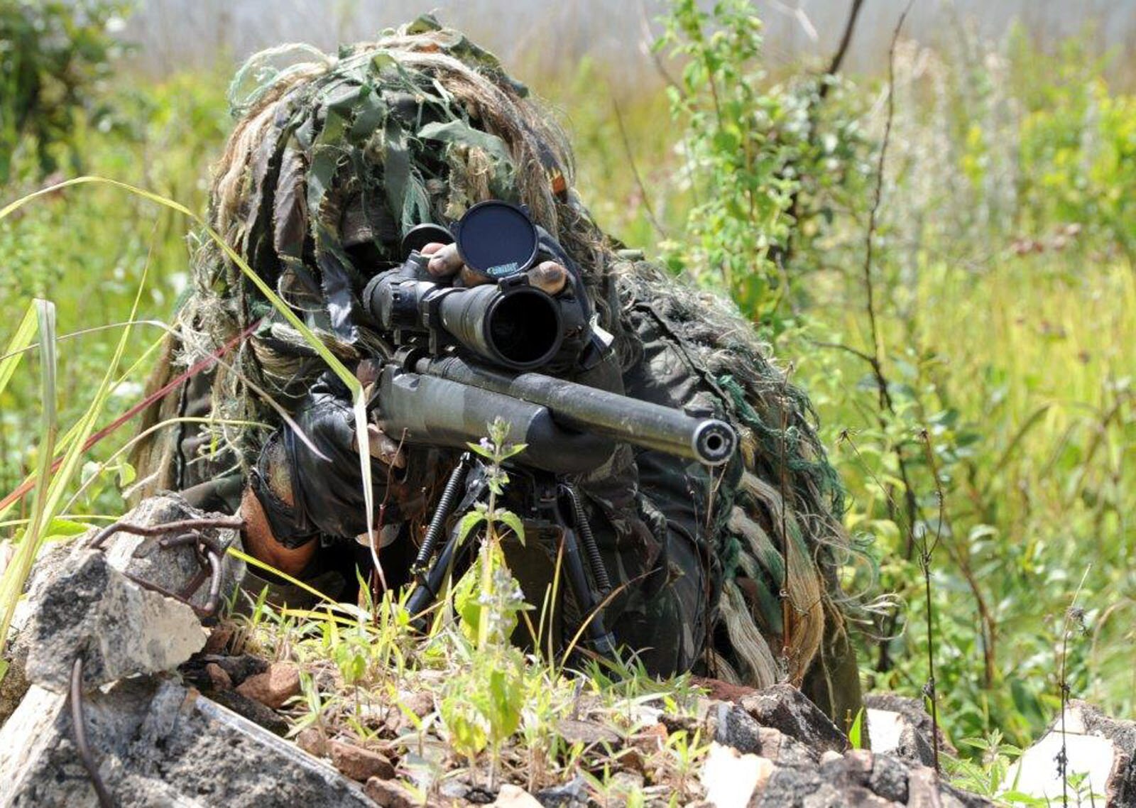 Sniper camuflado com arma de atirador nas mãos