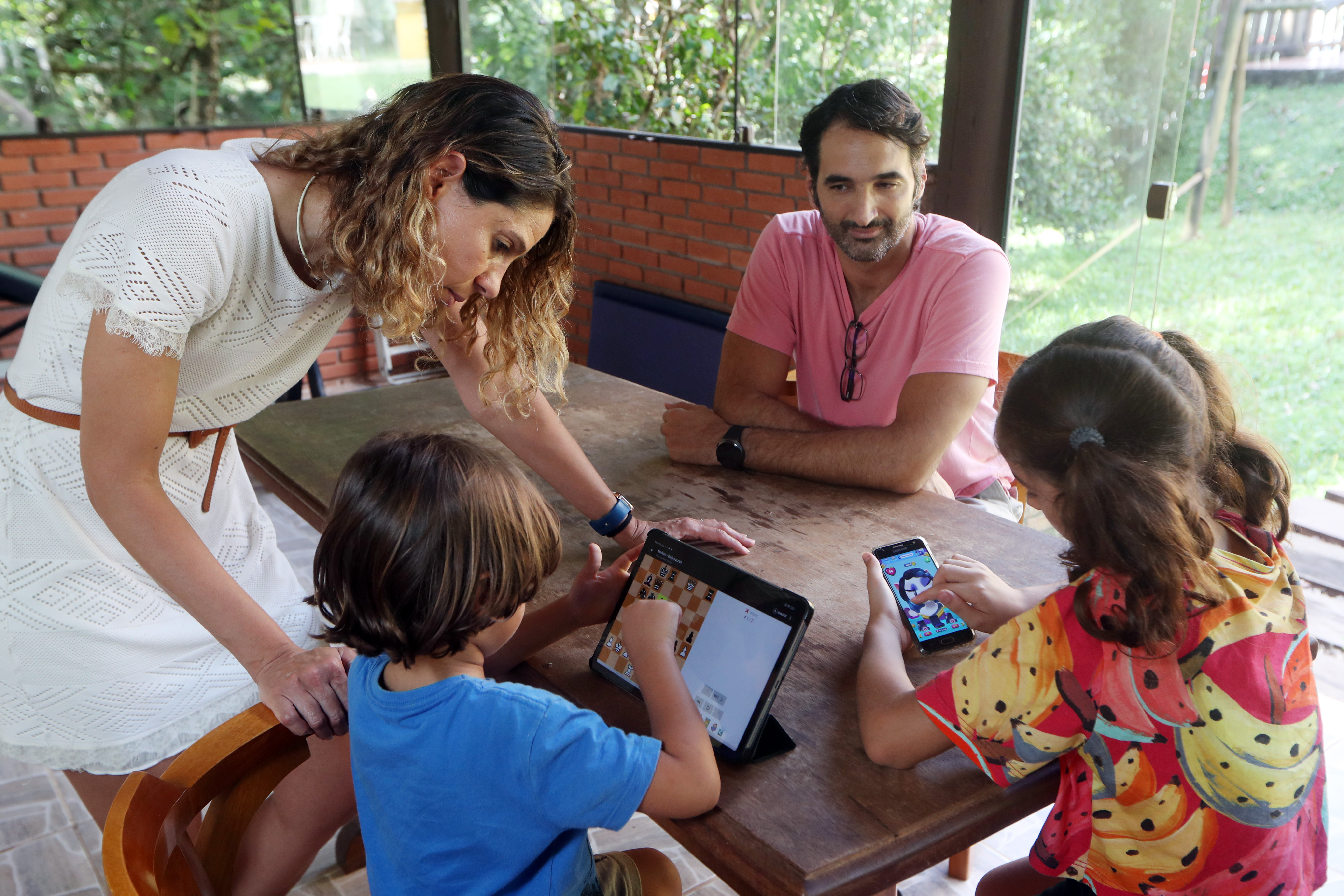 Mãe desligando videogame no computador para criança fazer lição