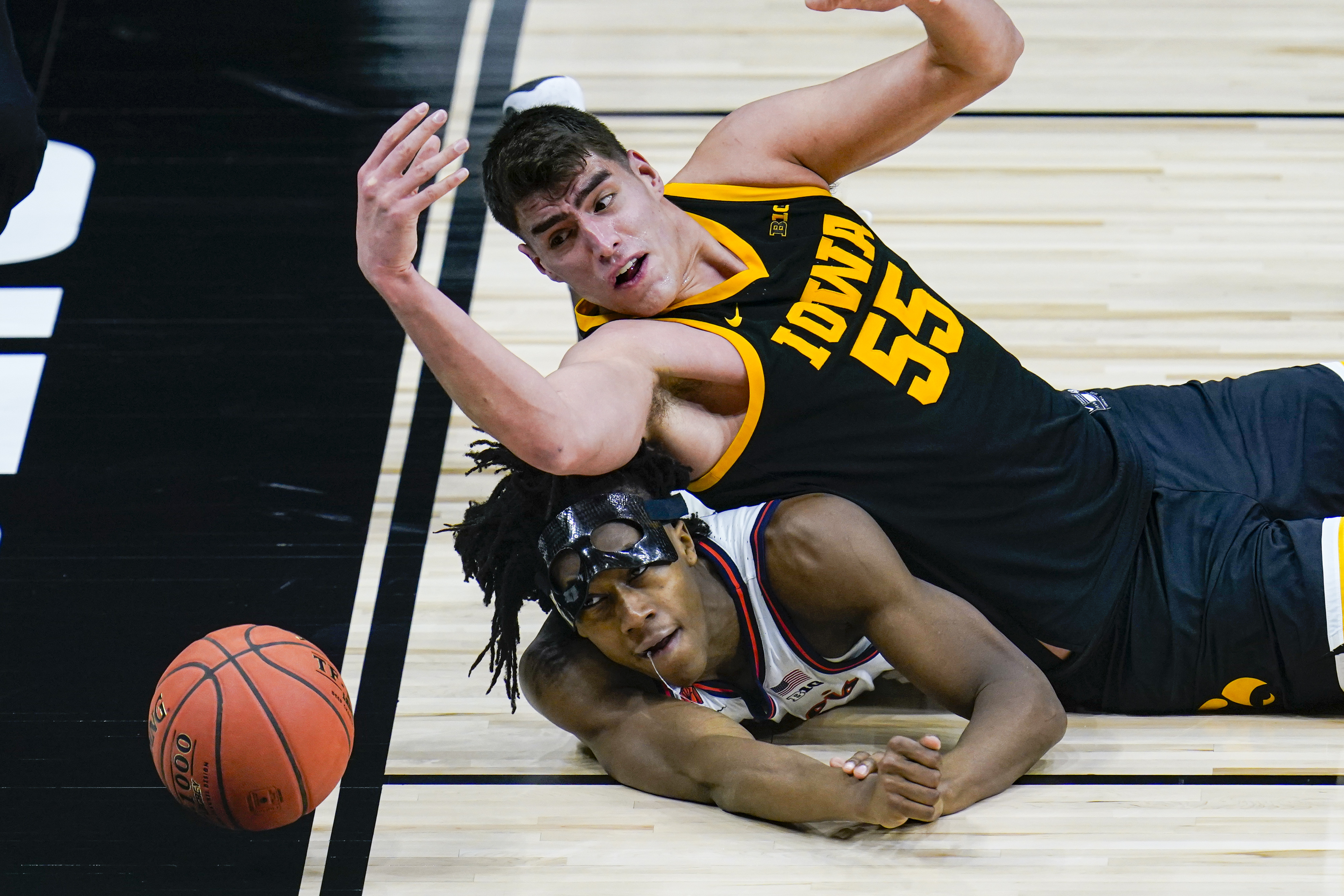 INDIANAPOLIS, IN - MARCH 13: Iowa Hawkeyes guard Jordan Bohannon (3) and  Illinois Fighting Illini guard Andre Curbelo (5) dive for a loose ball  during the men's Big Ten tournament college basketball