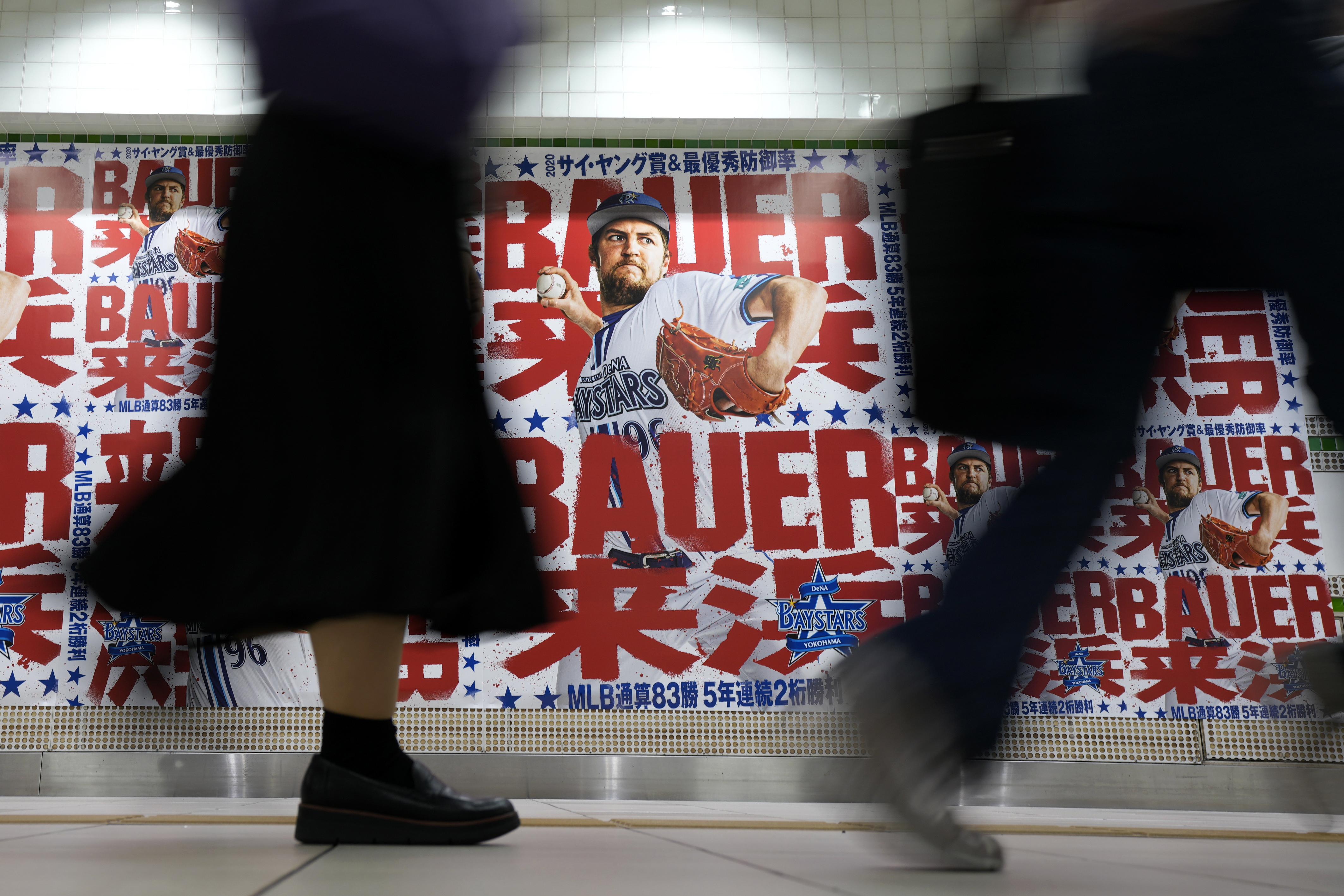 Trevor Bauer with his new uniform and cap of Yokohama DeNA BayStars poses  for photographers during a photo session of the news conference Friday,  March 24, 2023, in Yokohama, near Tokyo. (AP