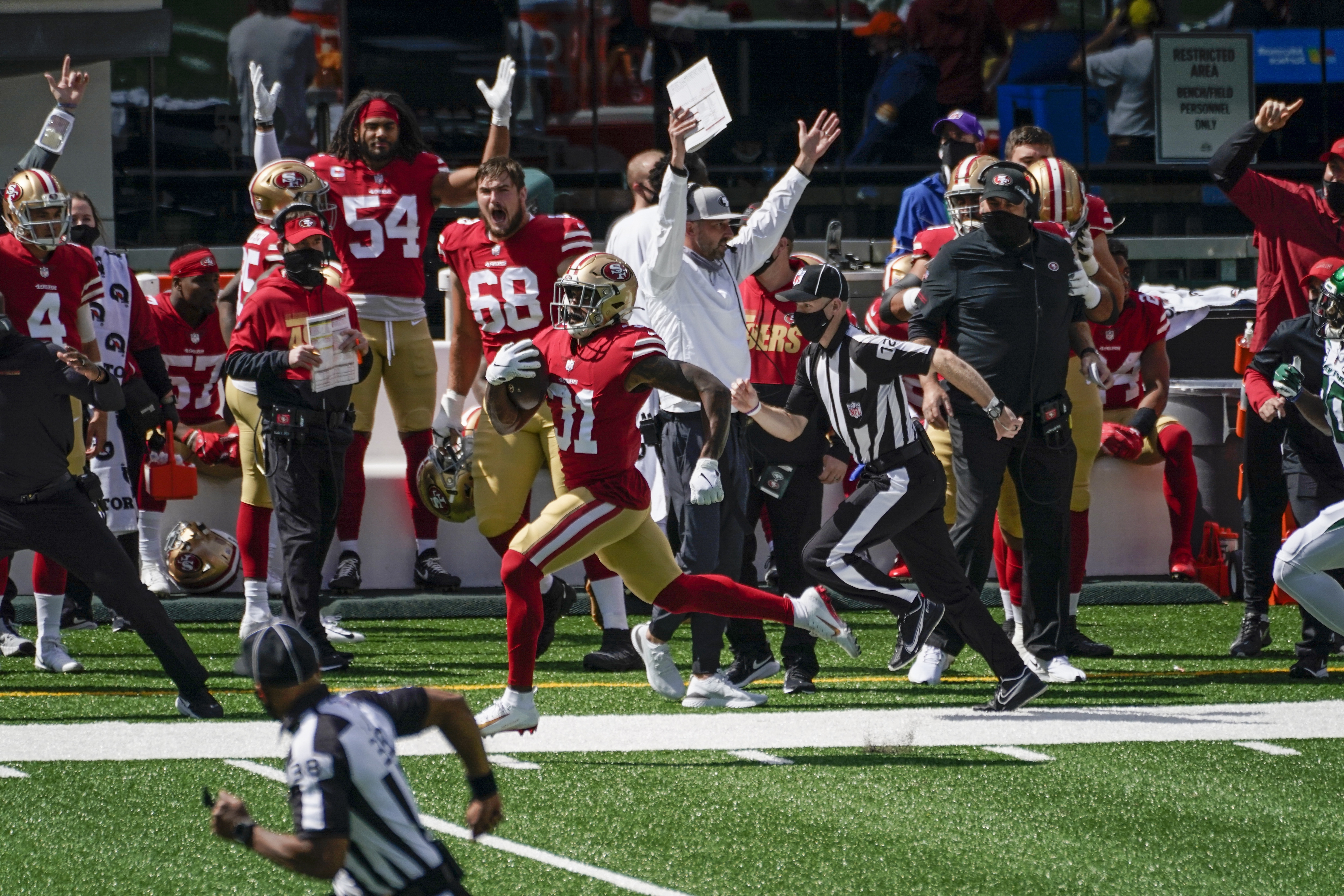 San Francisco 49ers Frank Gore (centre) breaks through the Denver