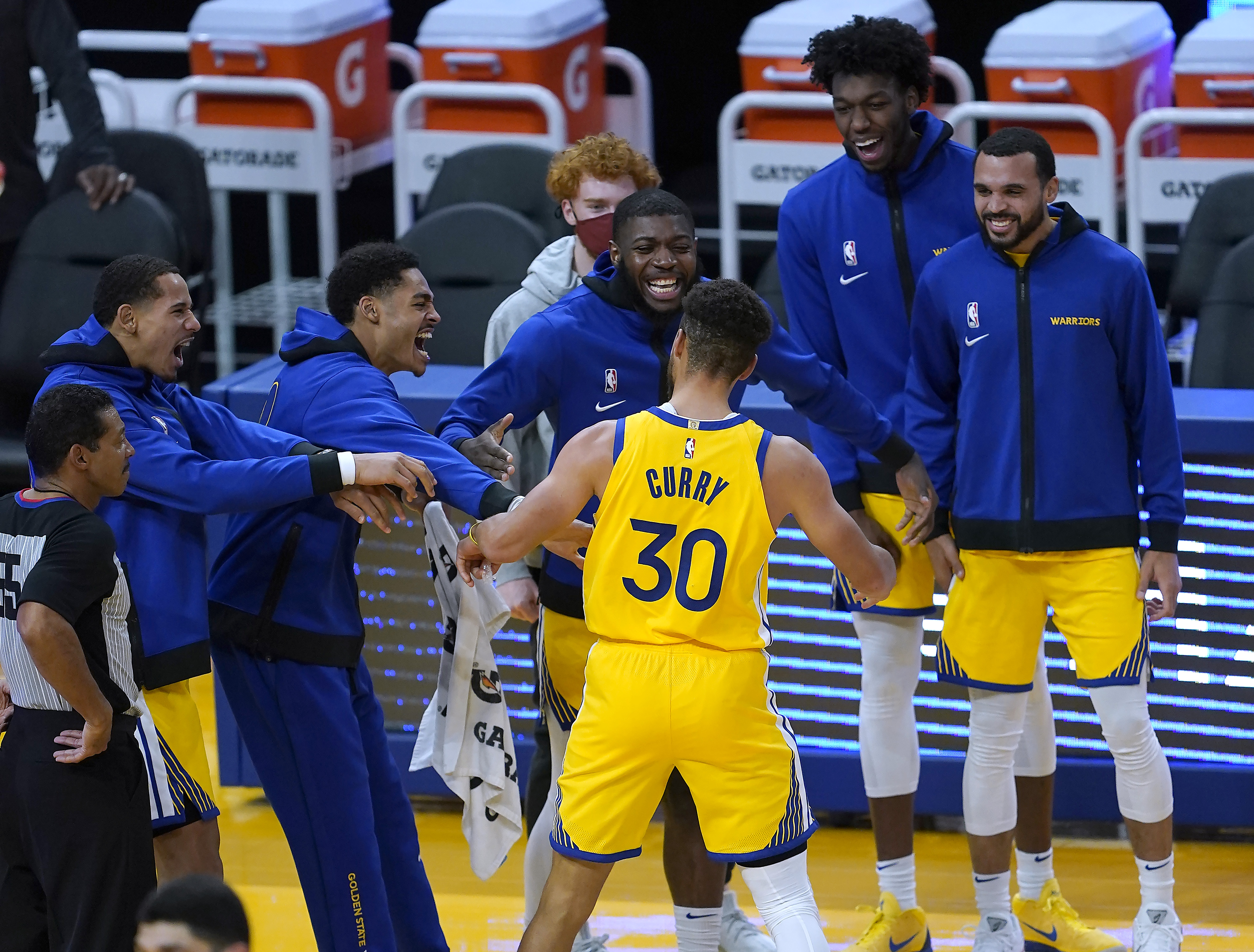 Golden State Warriors guard Damion Lee, right, pours water over the head of  guard Stephen Curry (30) while celebrating Curry's career-high 62 points  against the Portland Trail Blazers in an NBA basketball