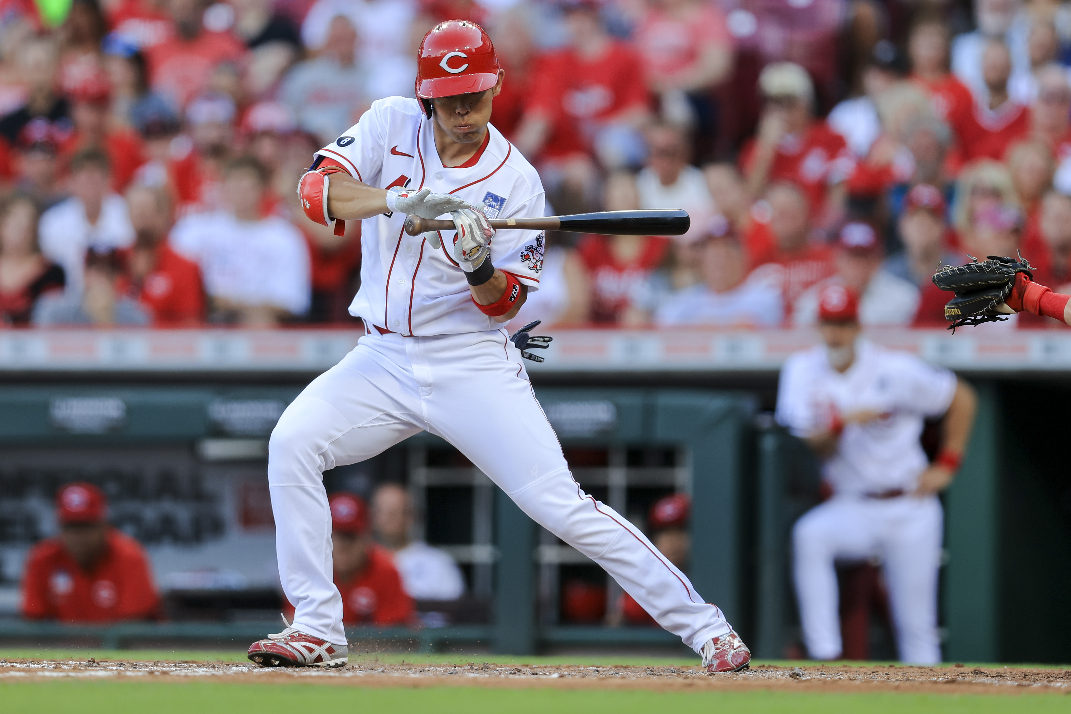 Cincinnati Reds center fielder Tyler Naquin, front, lies on the