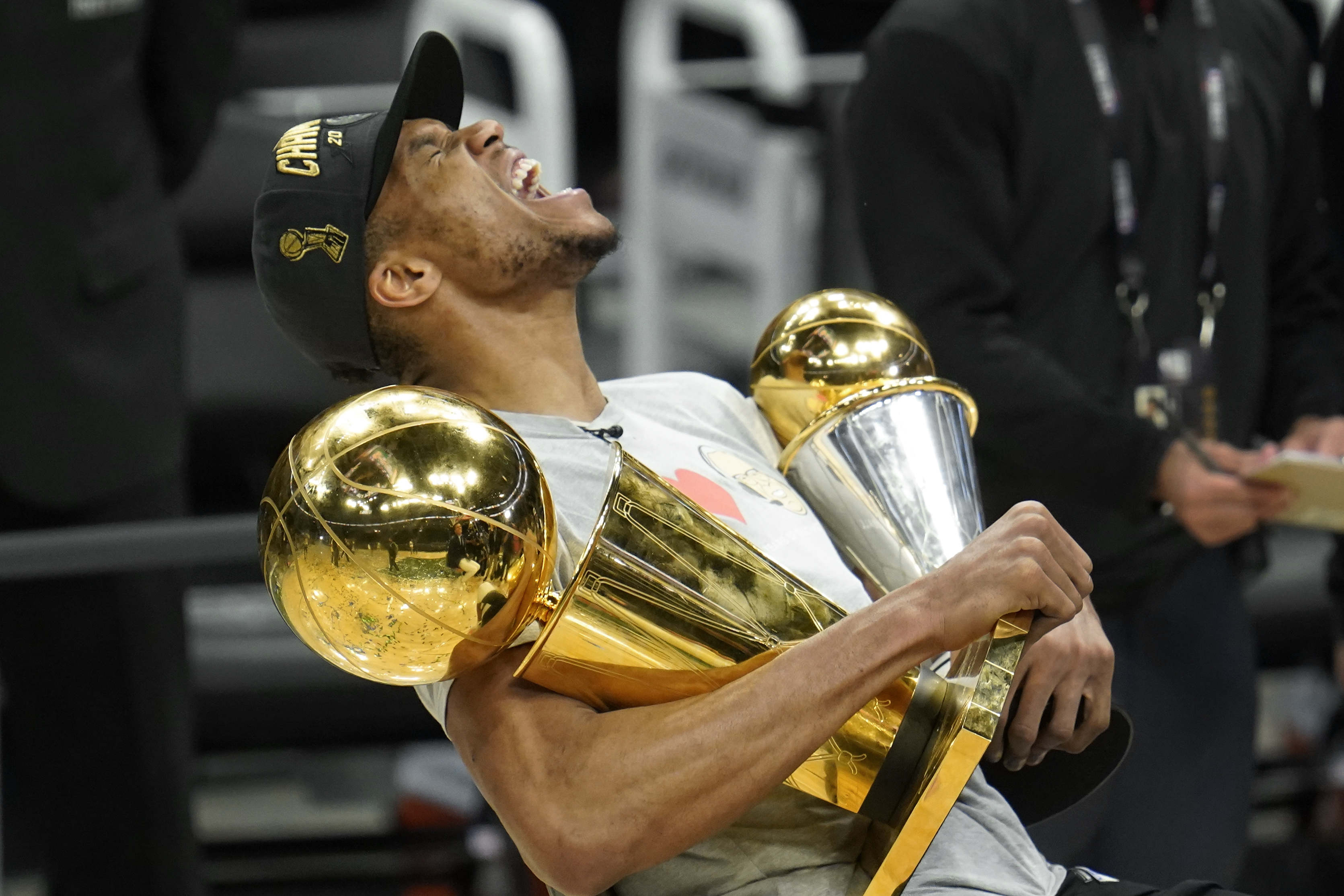 FILE - In this July 20, 2021, file photo, Milwaukee Bucks forward Giannis  Antetokounmpo holds the NBA Championship trophy, left, and Most Valuable  Player trophy after defeating the Phoenix Suns in Game