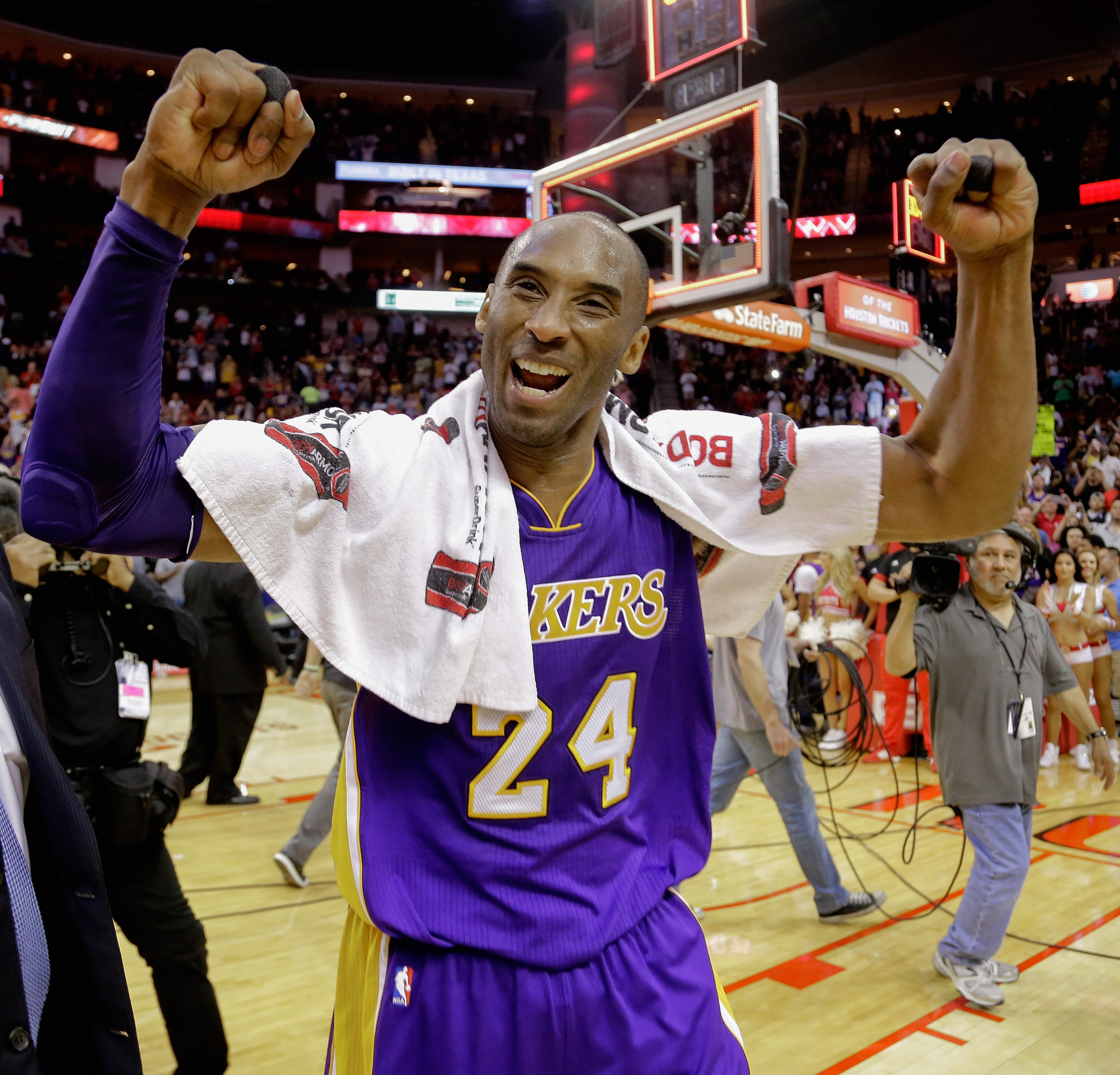 Kobe Bryant smiles and poses with a basketball wearing Laker home color  shoes and jersey at