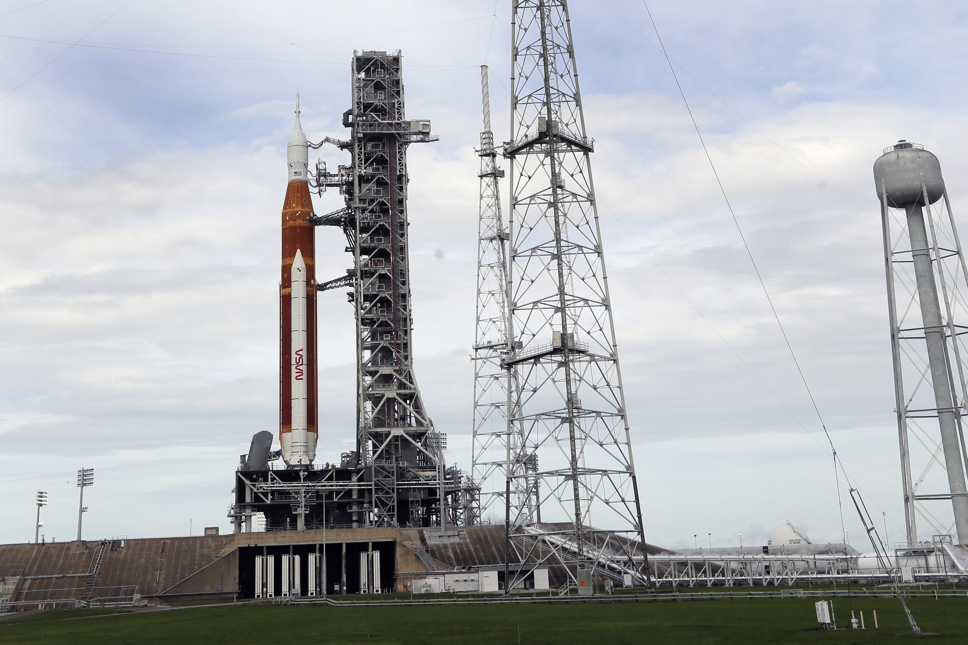 Spectators watch a sunrise from the Max Brewer Bridge while waiting to view  the launch on Pad 39B for the Artemis I mission to orbit the moon at the  Kennedy Space Center