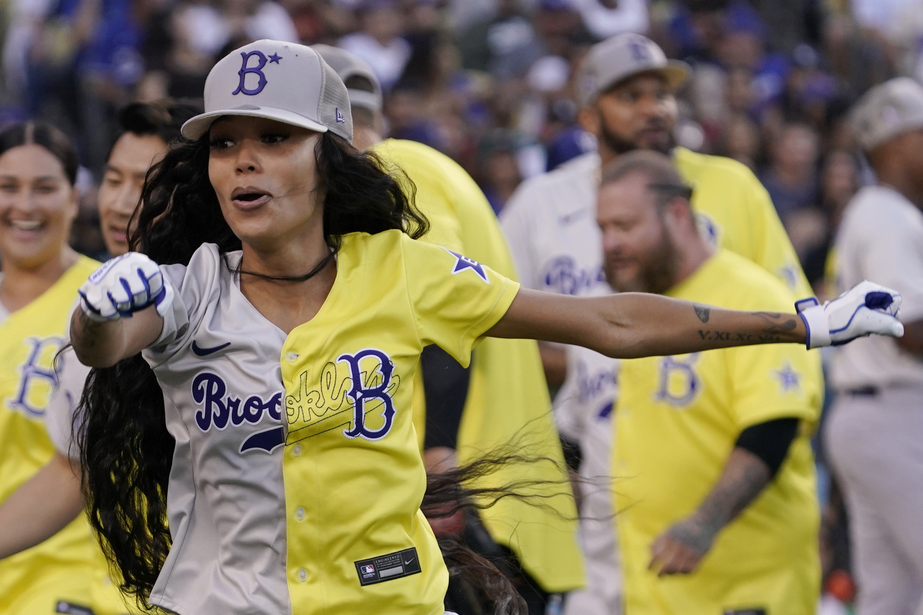Rapper and Singer Bad Bunny, right, talks to former Los Angeles Dodgers  player Shawn Green during the MLB All Star Celebrity Softball game,  Saturday, July 16, 2022, in Los Angeles. (AP Photo/Mark